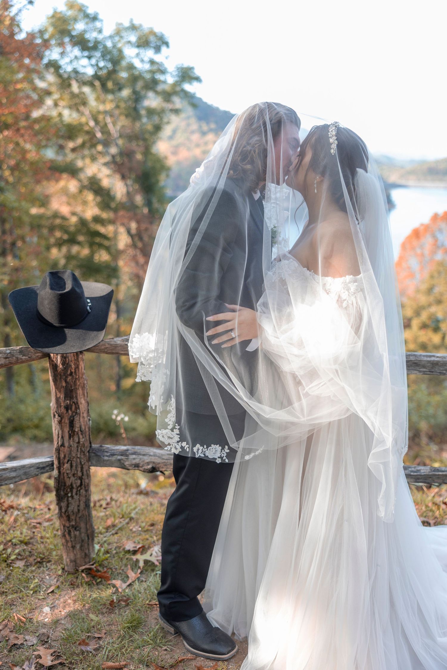 A romantic outdoor autumn wedding photoshoot featuring a couple embracing against a backdrop of fall foliage.