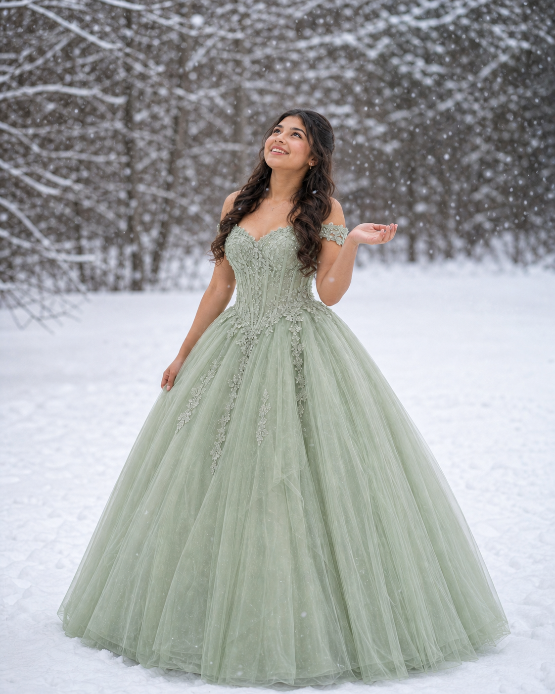Young woman in sage green ball gown with lace bodice poses gracefully in snowy winter landscape.