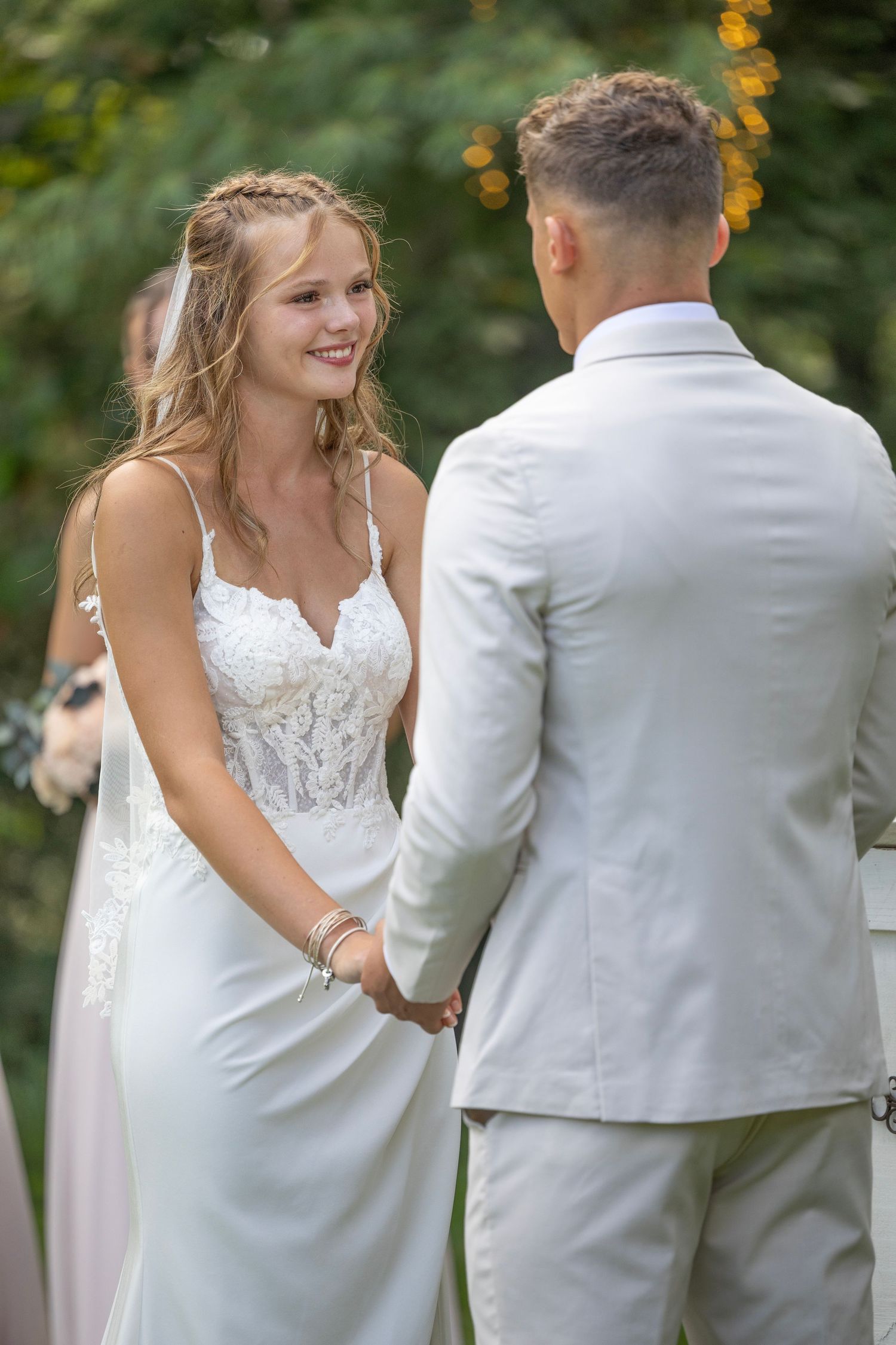 A joyful wedding couple shares a candid moment during their outdoor summer ceremony.