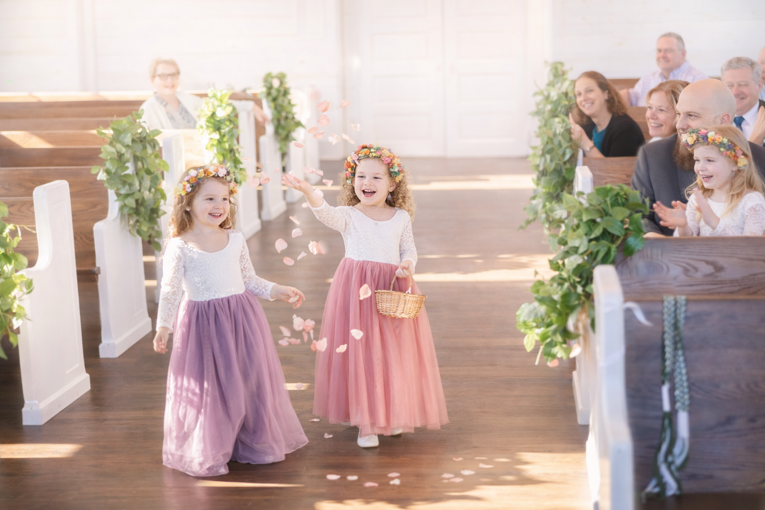 Children in pink and white dresses dance and twirl together during a special celebration.