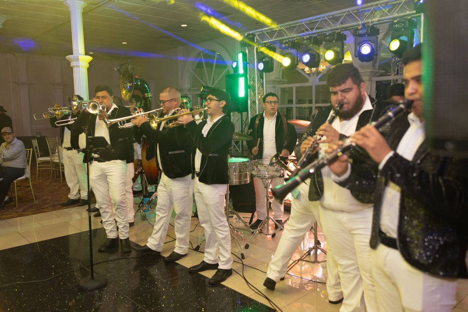 Live band performing at an event, musicians playing trumpets and clarinets in matching black and white outfits.