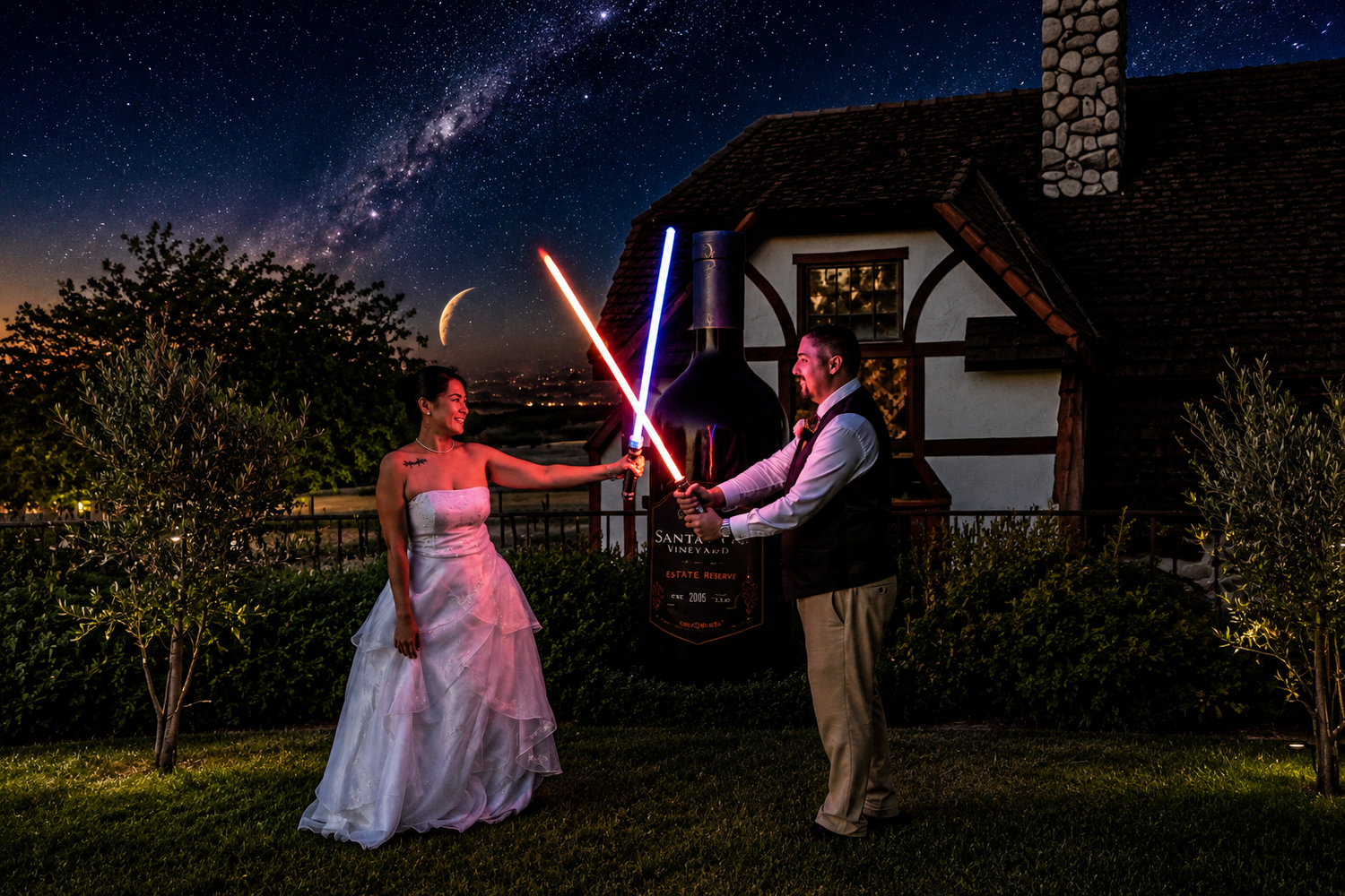 Bride and groom dueling with red and blue lightsabers under a starry night sky with the Milky Way visible.