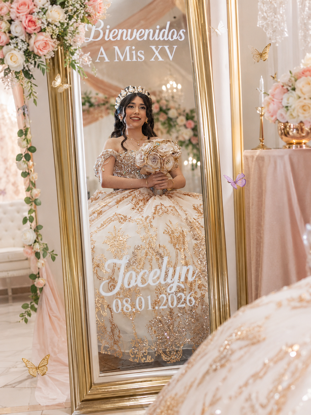 Young woman in gold quinceañera ball gown reflected in ornate mirror with Bienvenidos A Mis XV Jocelyn 08.01.2026 text.