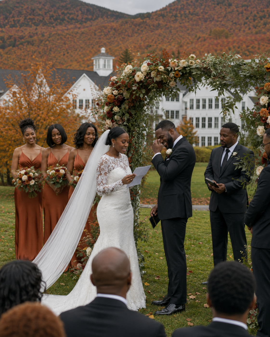 Outdoor fall wedding ceremony with bride in lace gown, groom in black suit, bridesmaids in rust dresses, floral arch, mountain backdrop.
