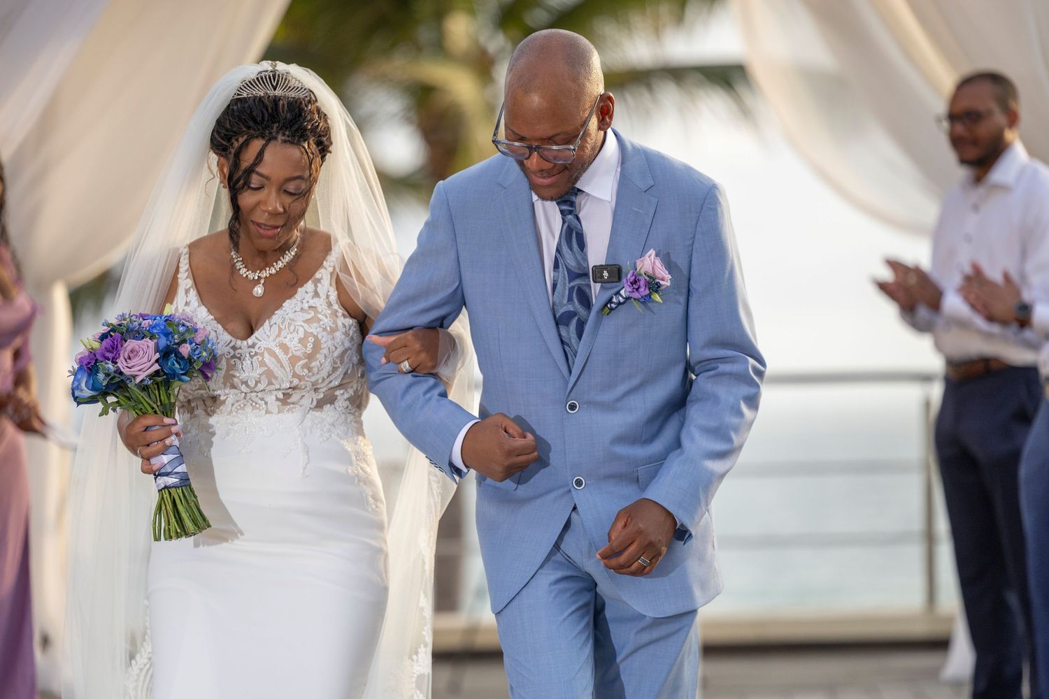 Wedding couple walks down the aisle together after ceremony in an elegant outdoor setting.