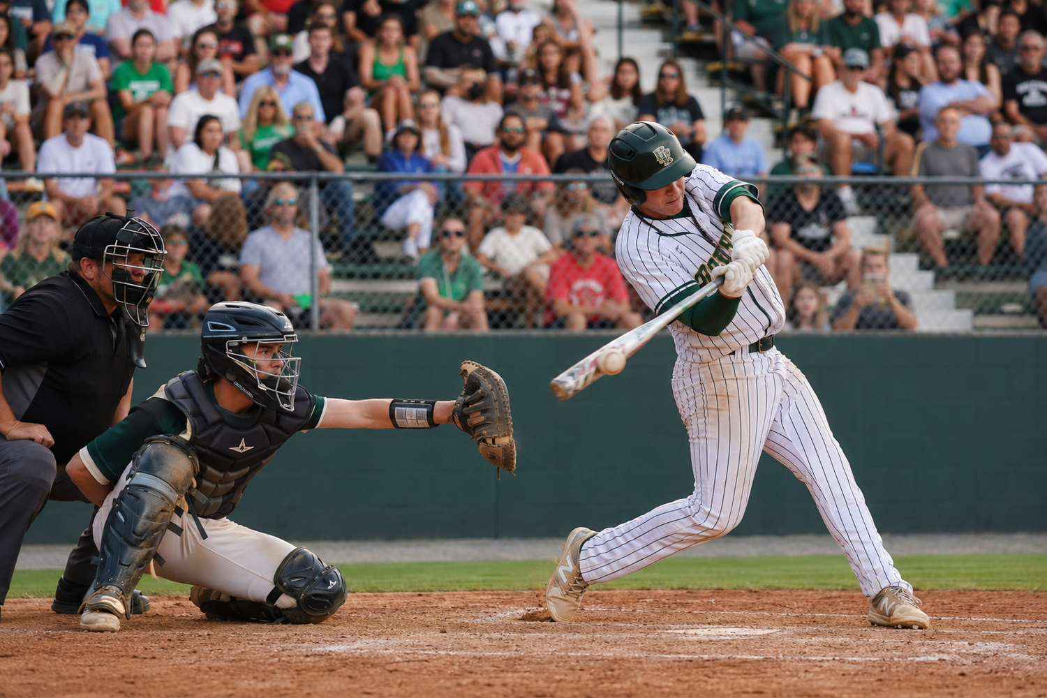 Baseball batter swings at pitch with catcher and umpire during a packed stadium night game.
