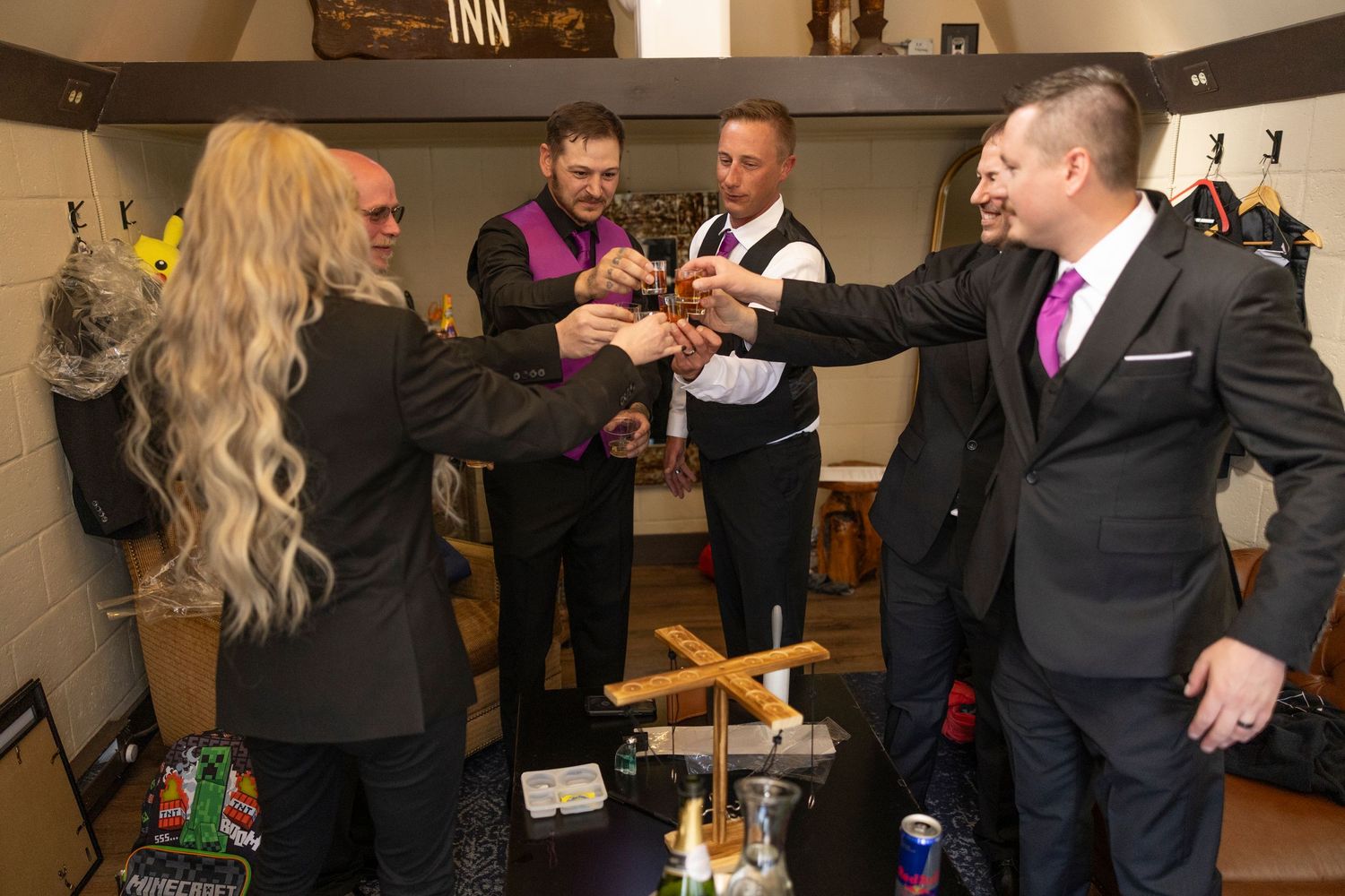 A group of formally dressed people raise glasses in a celebratory toast at what appears to be a social gathering.