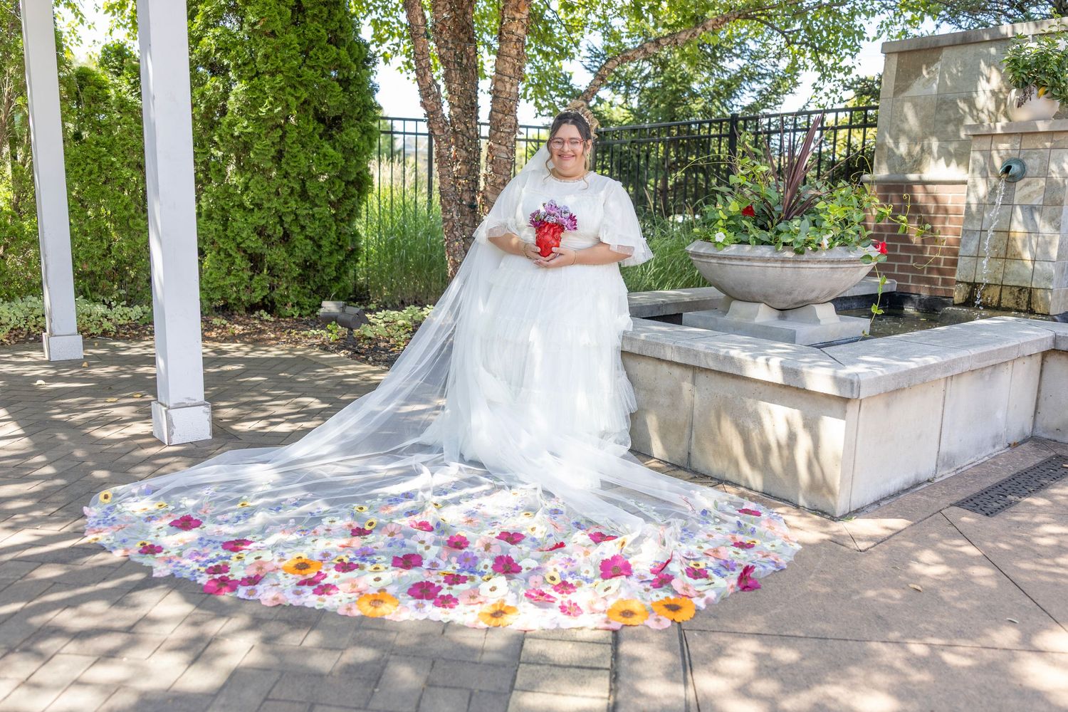 A row of outdoor garden benches arranged along a stone path with scattered pink flower petals creating a romantic setting.