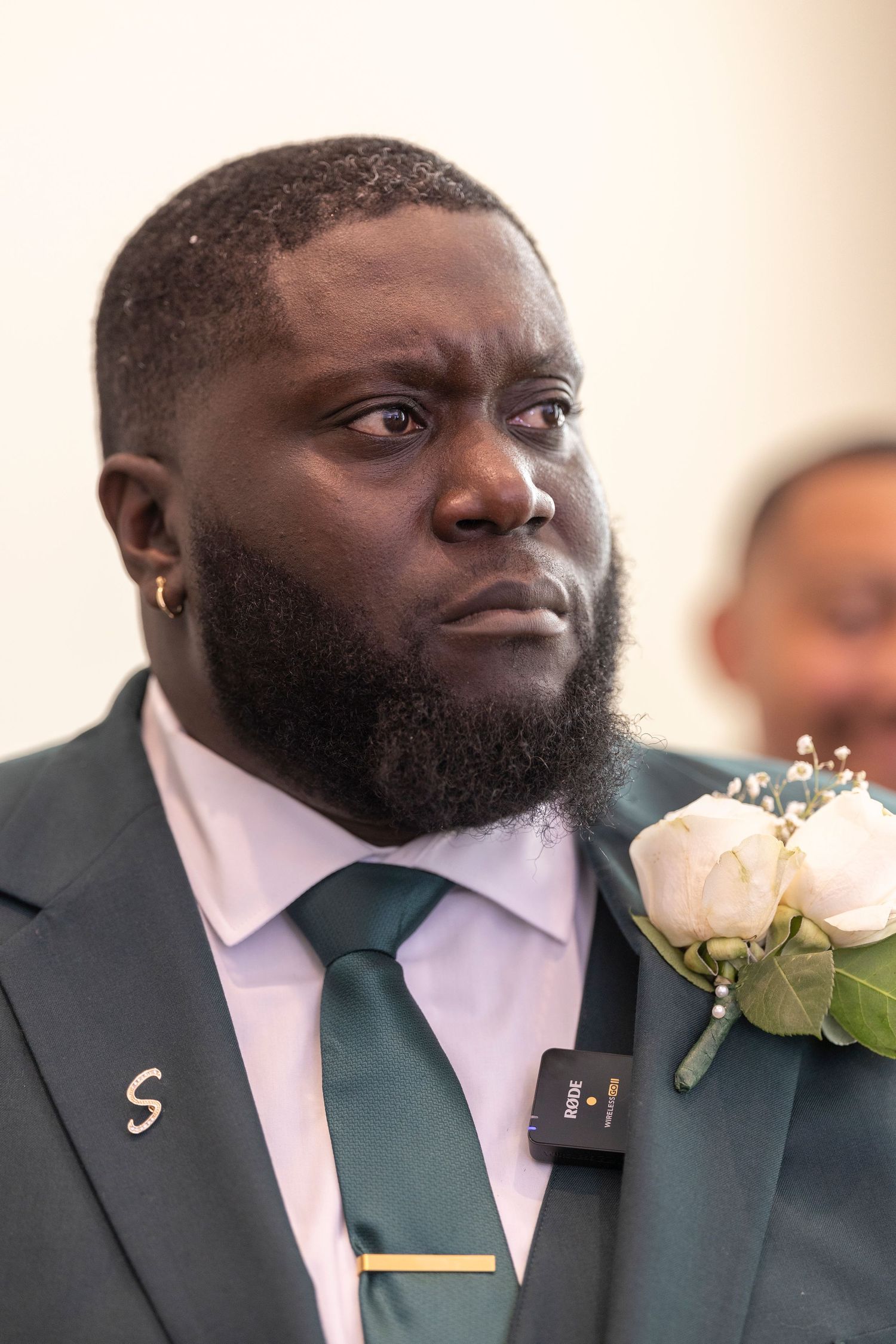A series of close-up shots showing a person in a dark green tie and white shirt with a floral boutonniere.