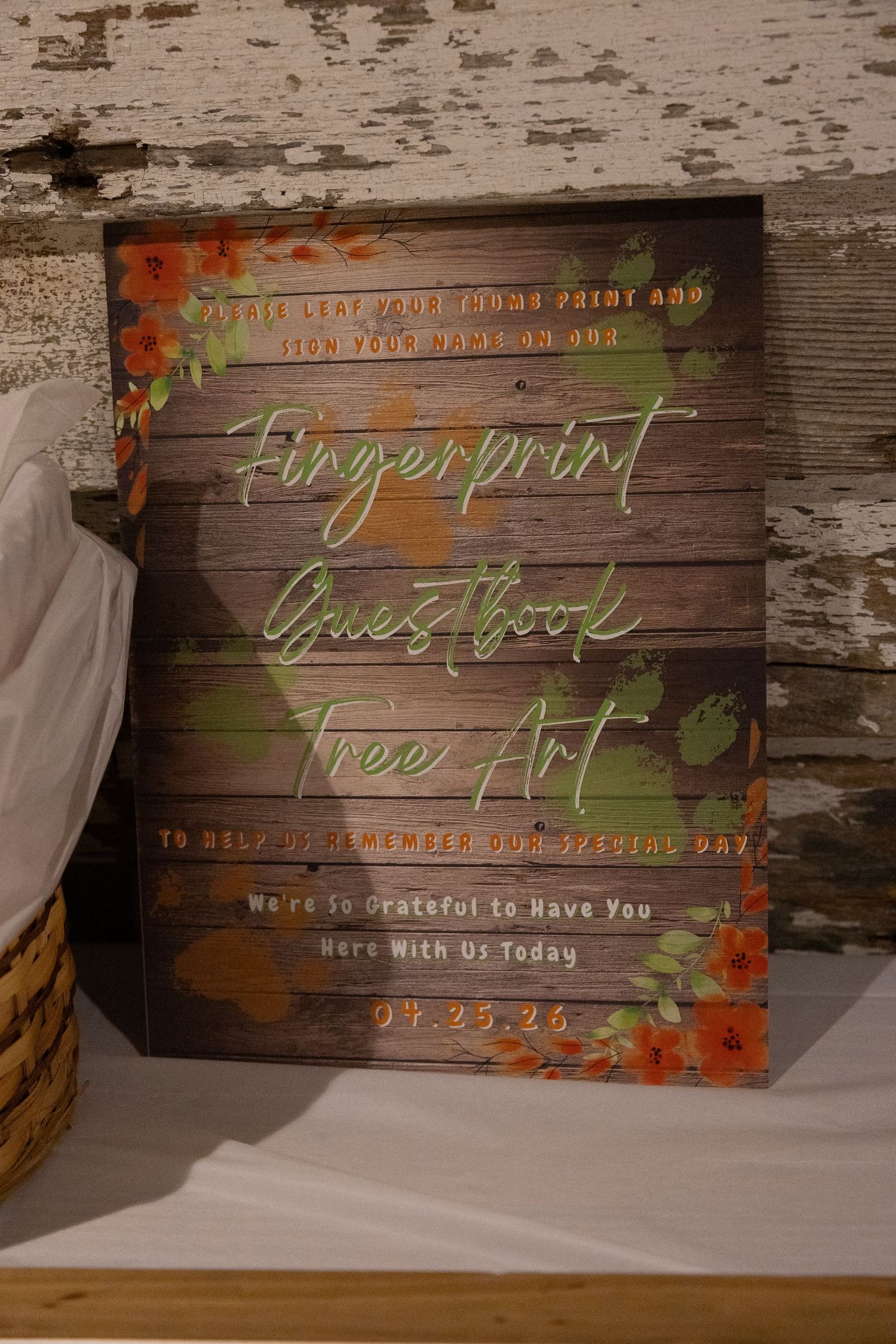 Rustic wooden fingerprint guestbook tree art sign with floral accents for a wedding dated 07.25.26.