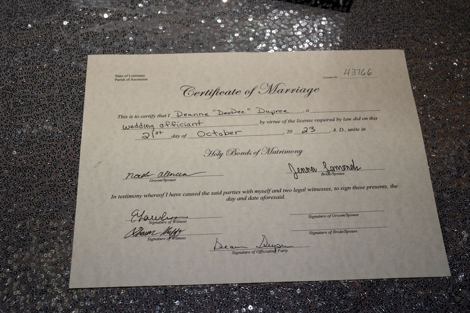 A vintage certificate of marriage document laid on a dark textured surface with partial text visible.