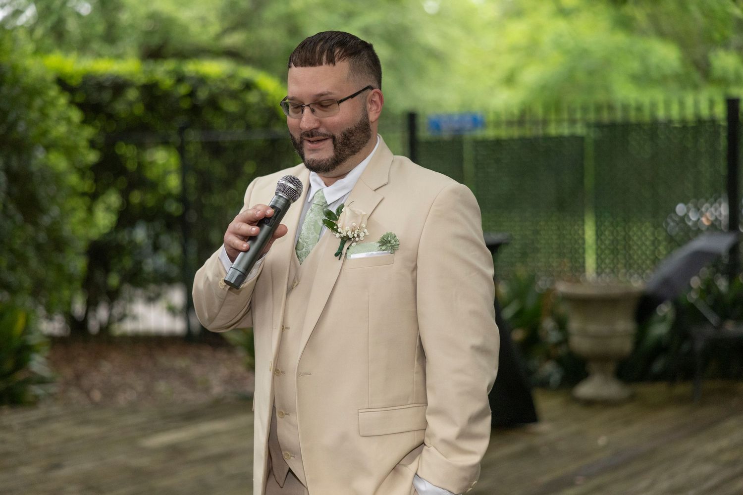 Multiple photos show a person in a beige suit and glasses holding a phone in an outdoor garden setting.
