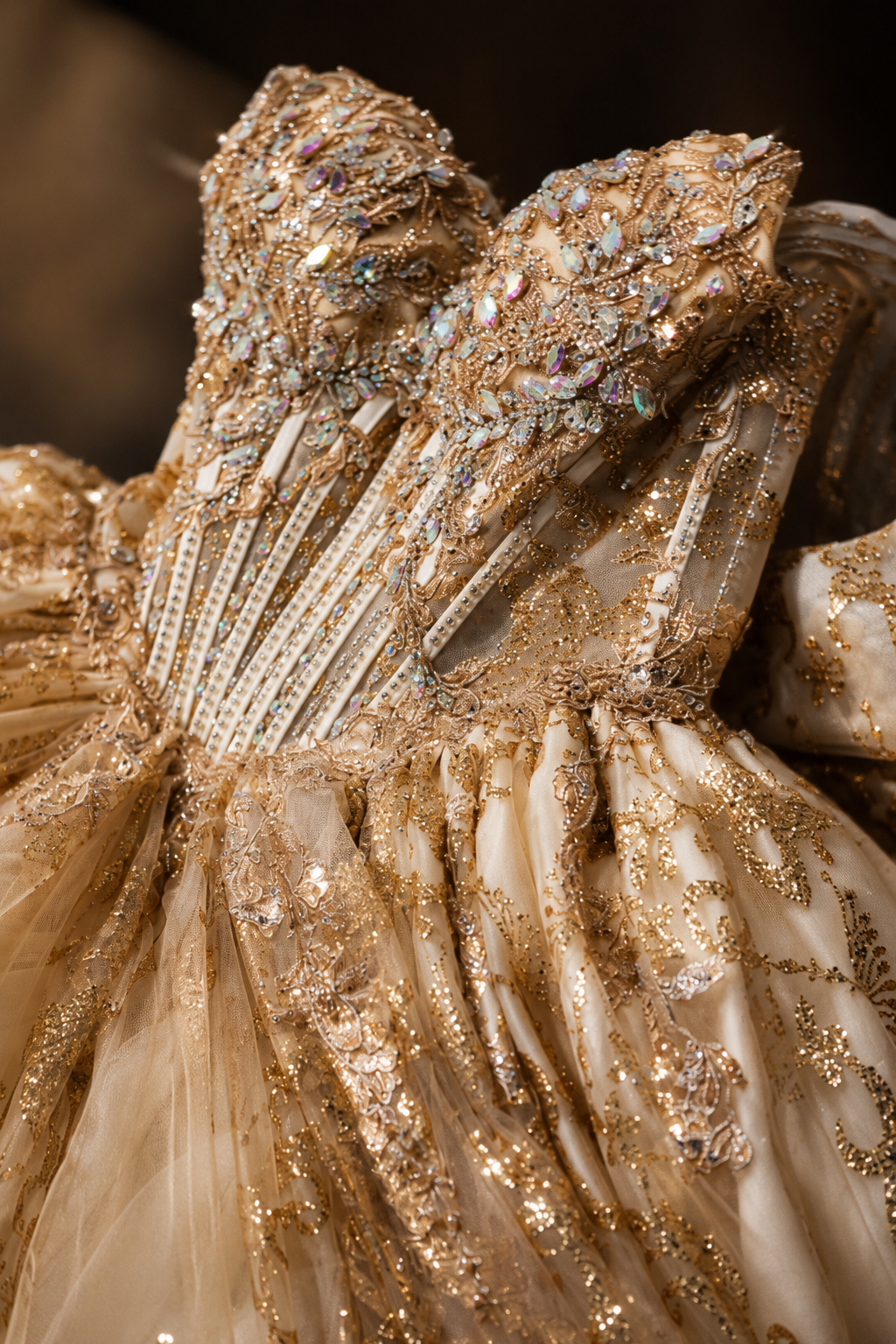 Ornate gold ballgown bodice adorned with iridescent beading, sequins, and intricate embroidery on luxurious layered tulle fabric.