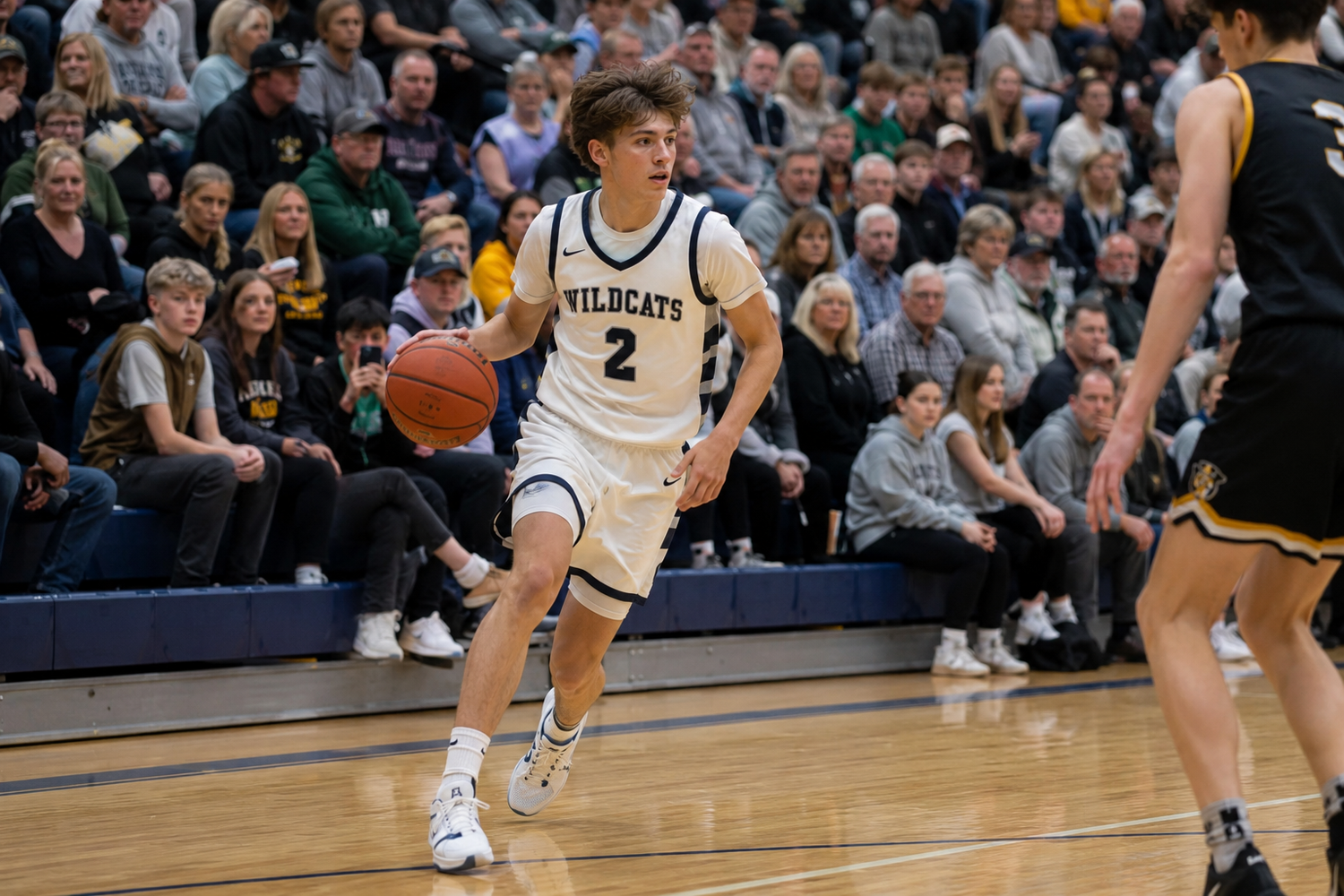 Wildcats basketball player number 2 dribbles the ball during a crowded home game.