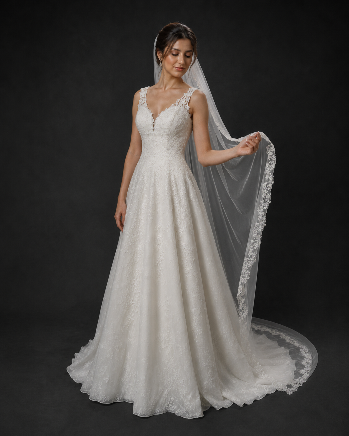 Elegant A-line wedding dress with lace bodice, deep V-neckline, and cathedral veil with lace trim.