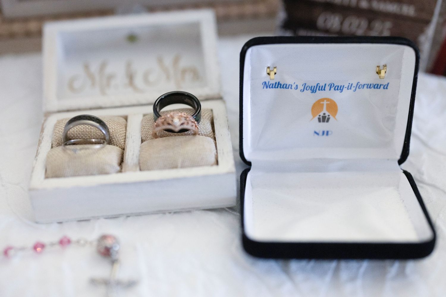 Assorted small jewelry boxes and display cases arranged in a row on a white surface.