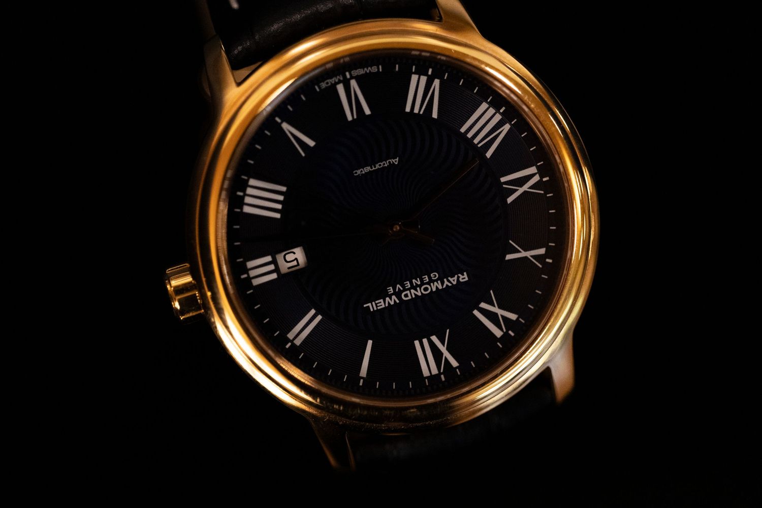 A luxury watch with a black dial and gold case shown from six different angles displaying Roman numeral markers.