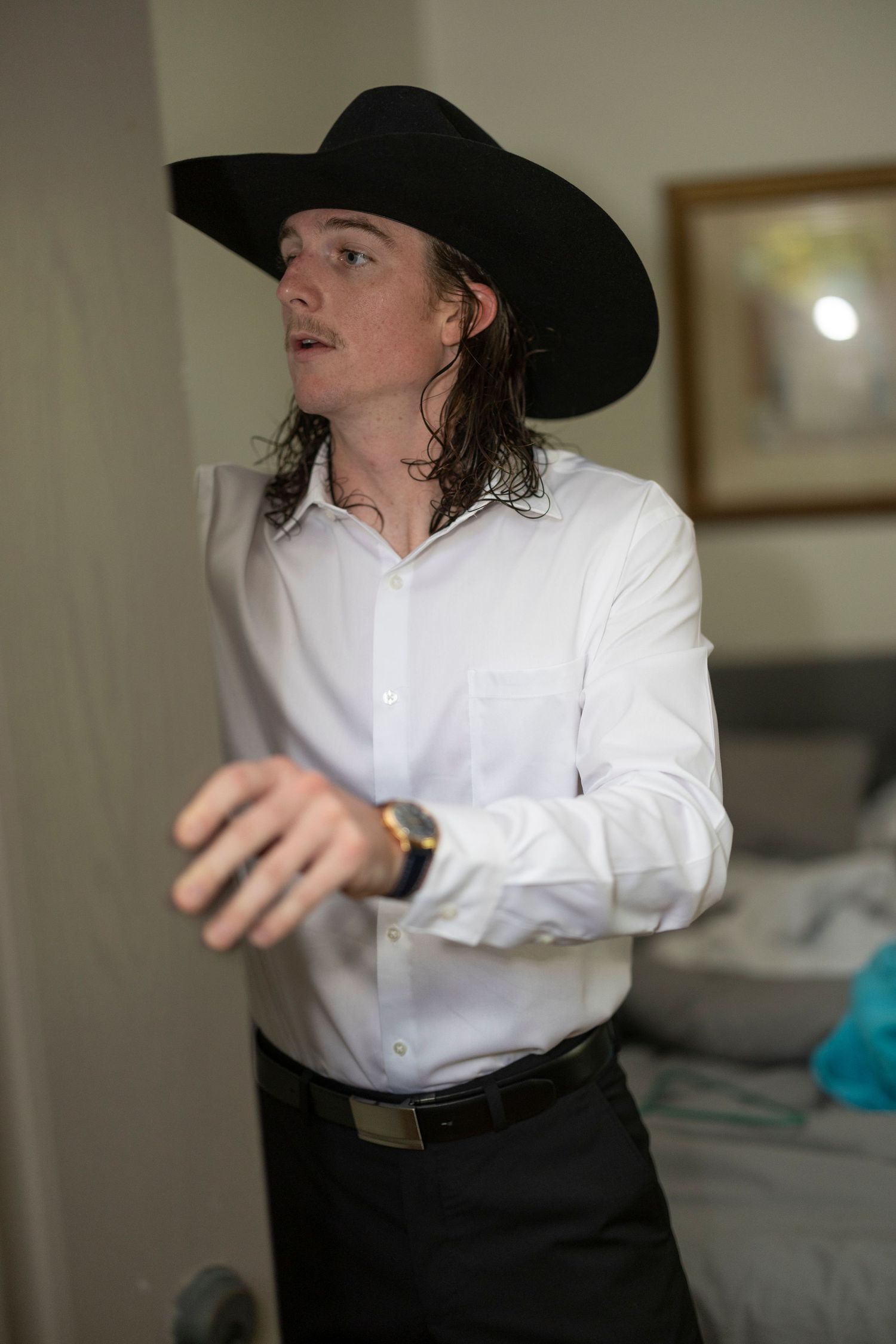 Person in a white shirt and black cowboy hat gestures dramatically in a sequence of motion shots.
