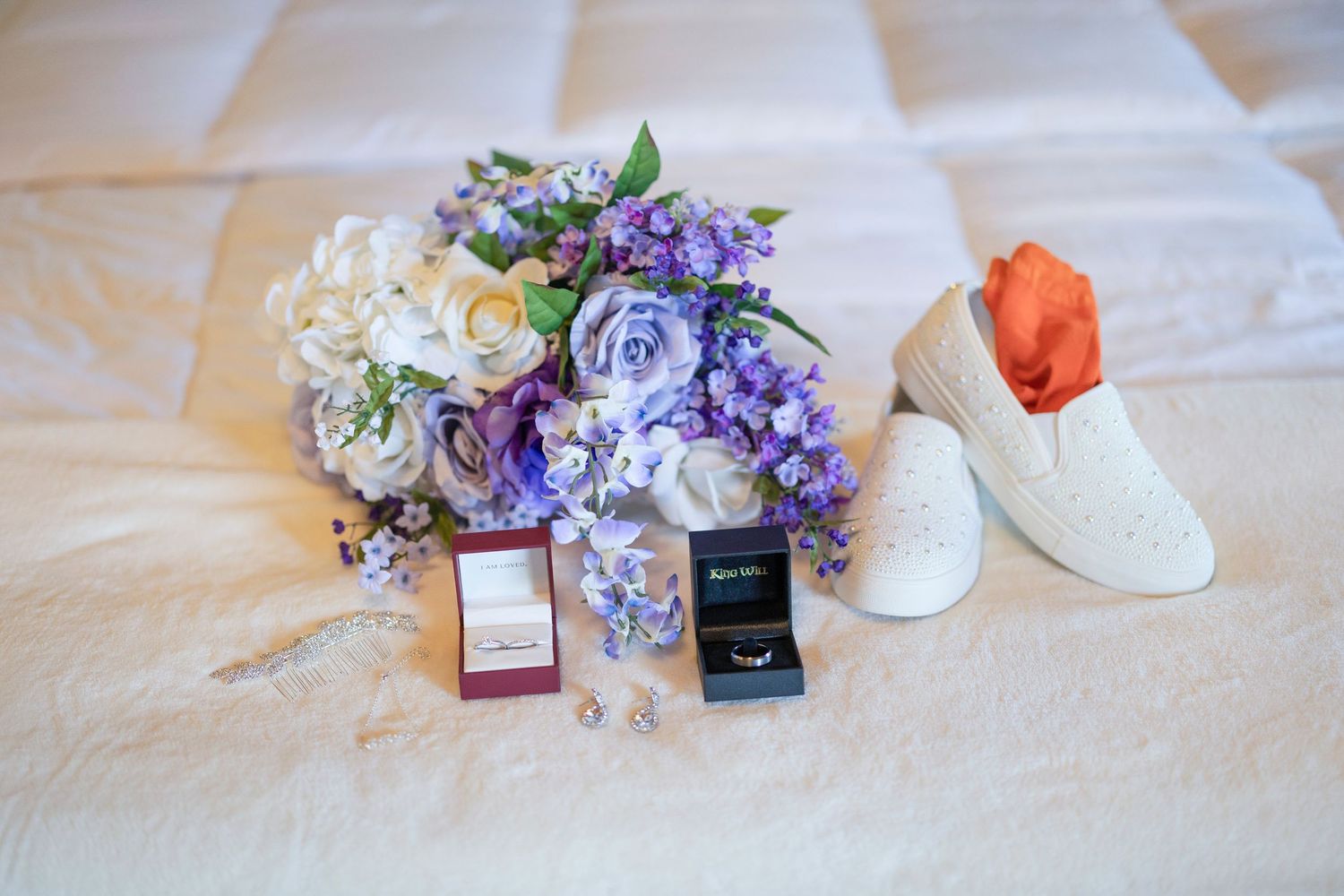 Wedding details including flowers, rings, shoes, and passports arranged on a white surface.