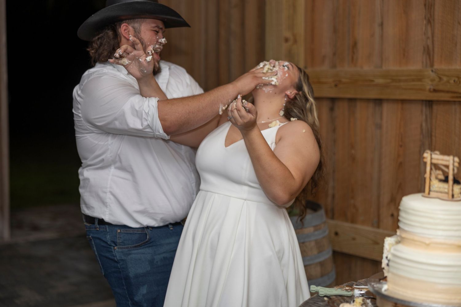 A series of photos showing a wedding couple cutting and feeding each other cake during their rustic barn reception.