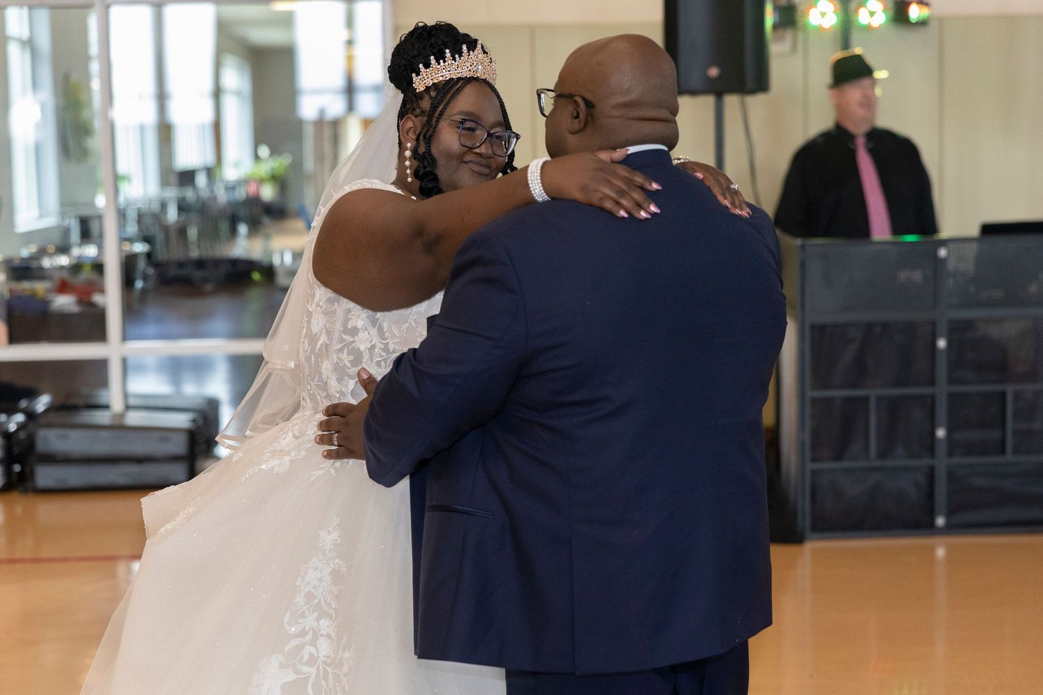 Bride and groom sharing their first dance at wedding reception, bride wearing white gown and tiara.