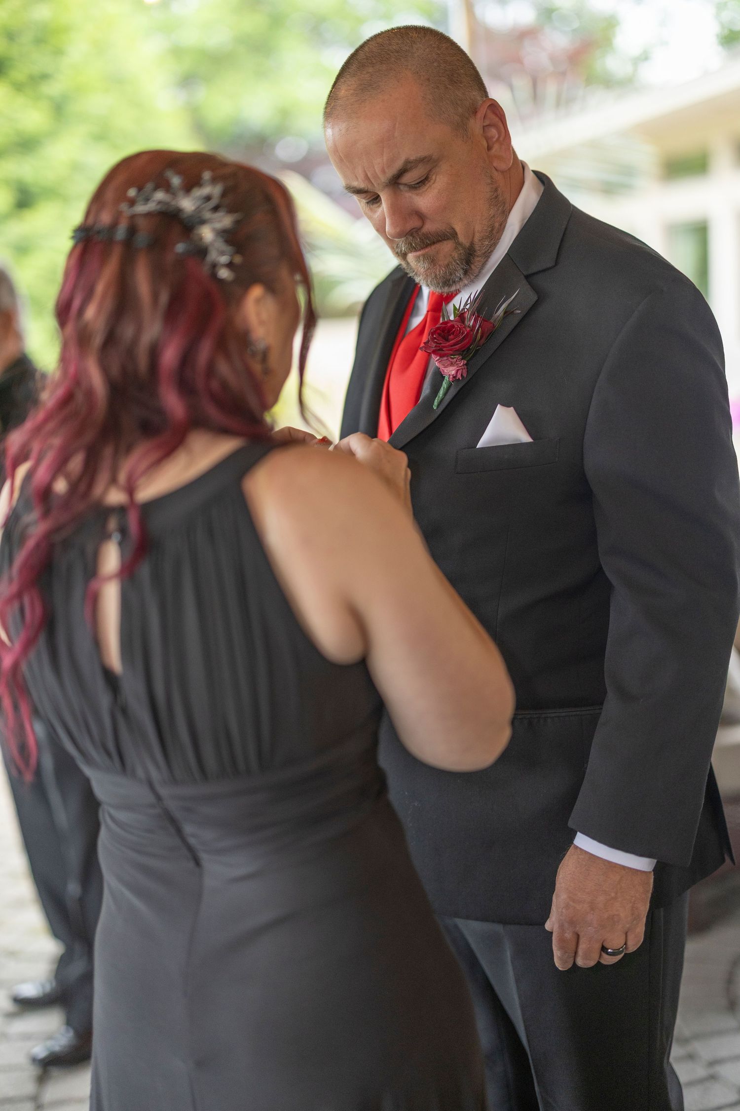 A couple in formal attire dance together at an event, with the woman wearing black and the man in a dark suit.