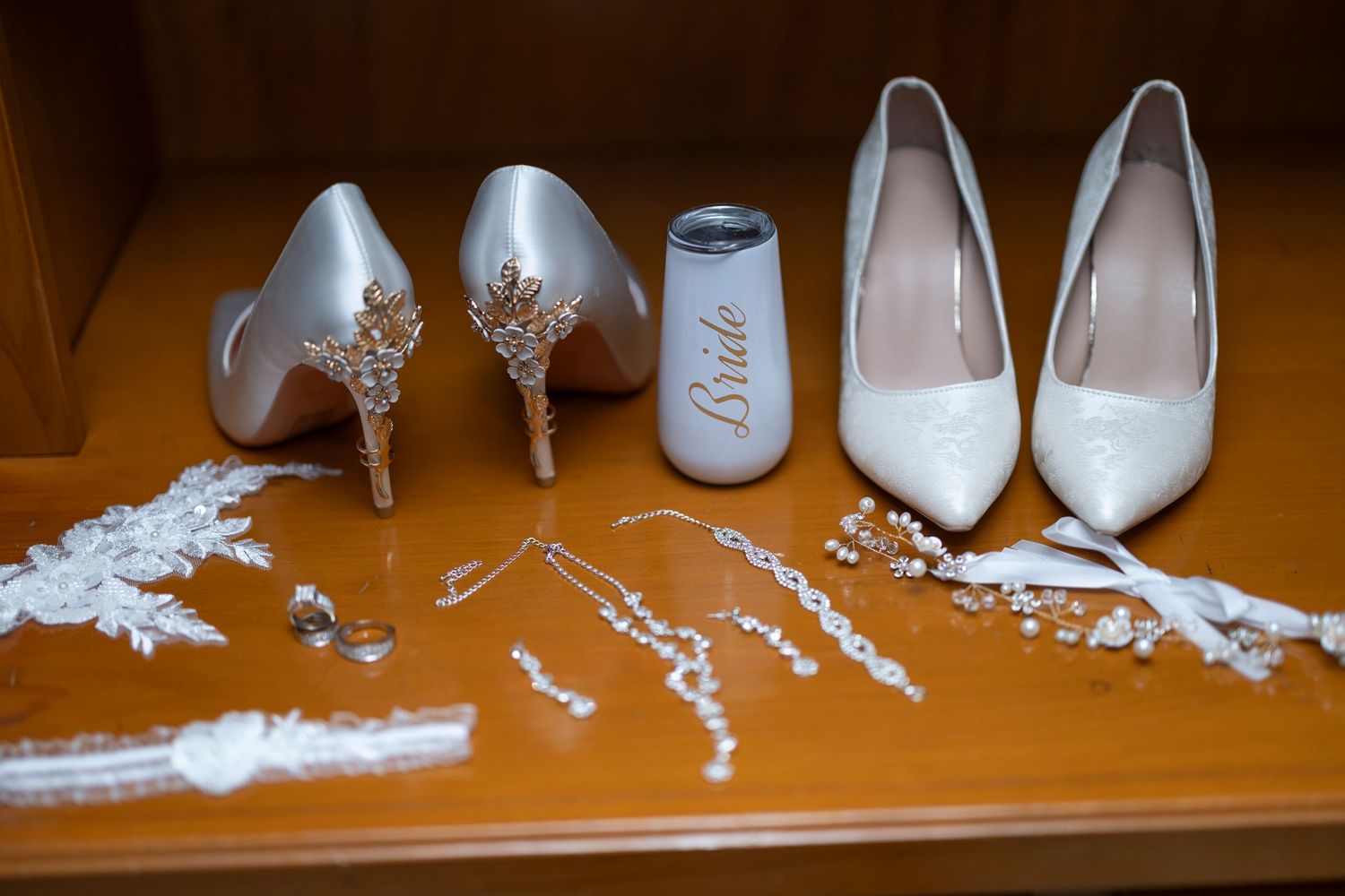 White ballet pointe shoes and ribbons arranged in a sequence showing the steps of attaching ribbons to dance shoes.