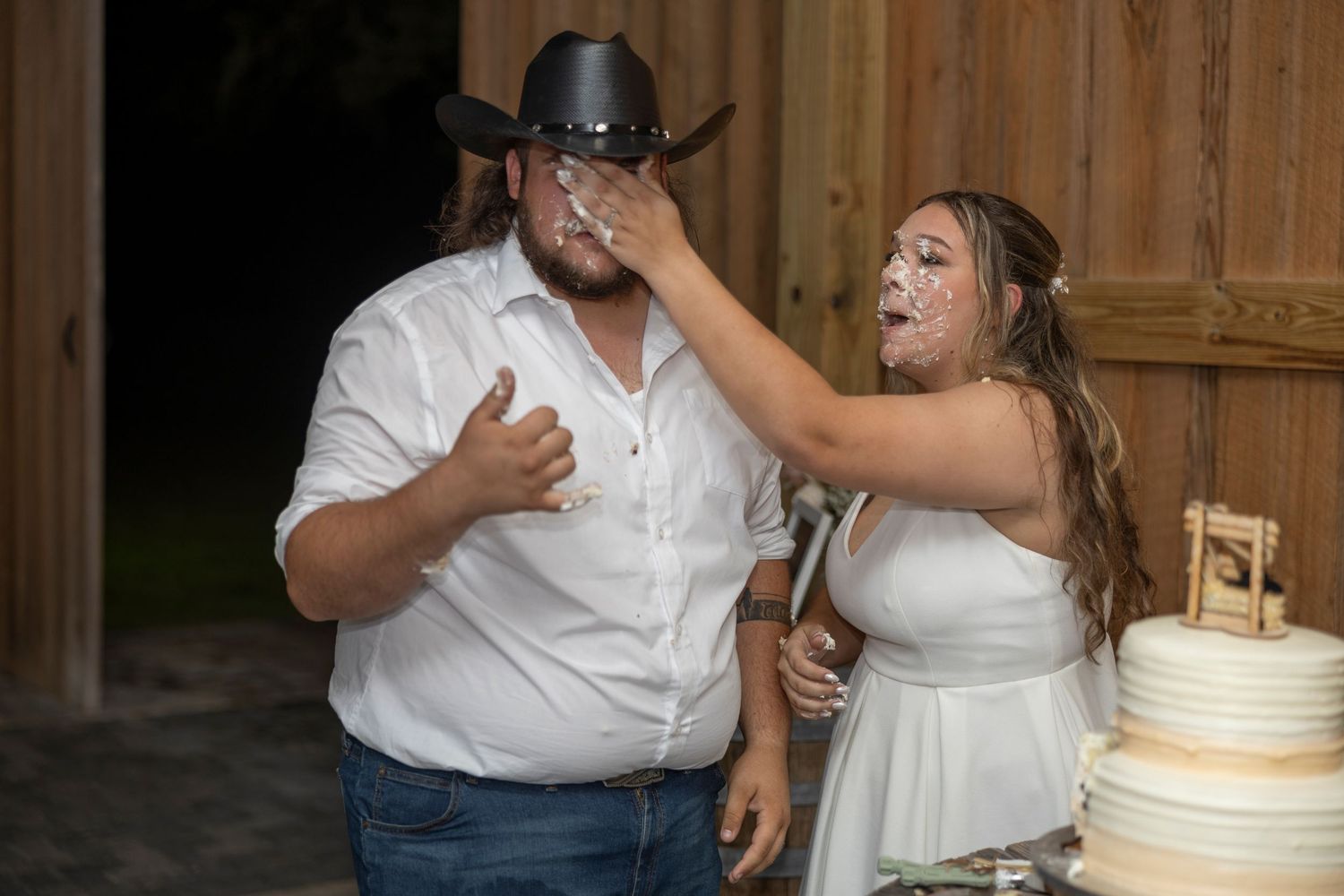 A couple in wedding attire share their first dance together while guests watch at a reception venue.
