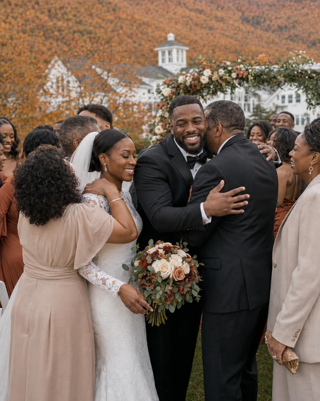 Newlyweds celebrate with wedding party outdoors, surrounded by guests with vibrant autumn foliage and white venue behind.