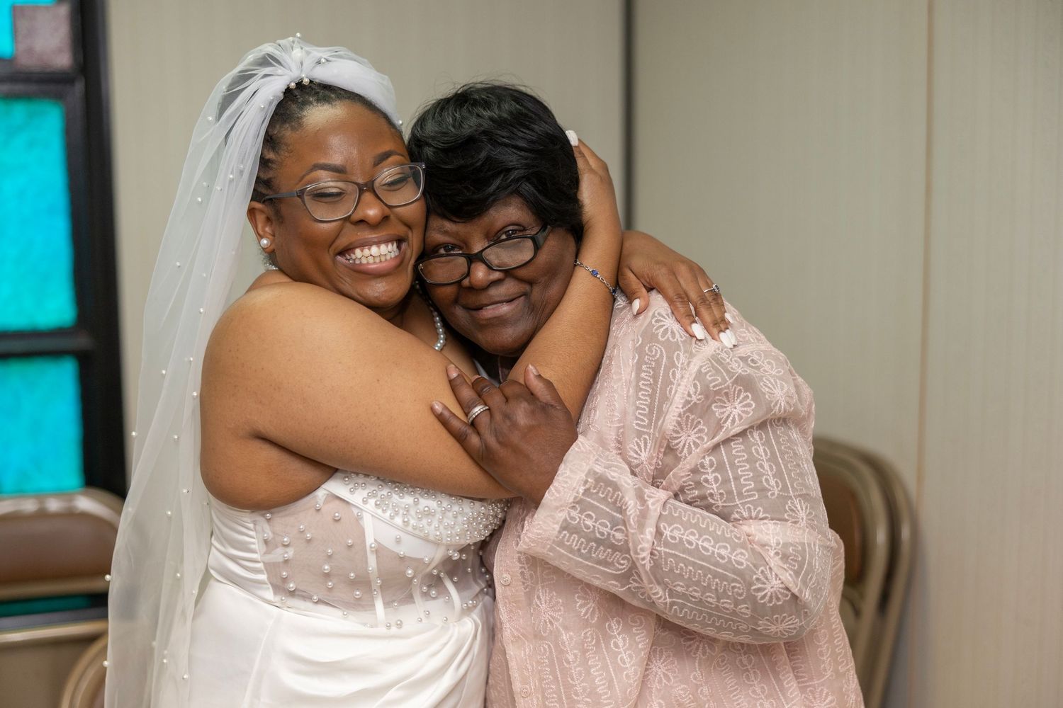 A joyful wedding celebration showing candid reactions and laughter between people in formal attire.