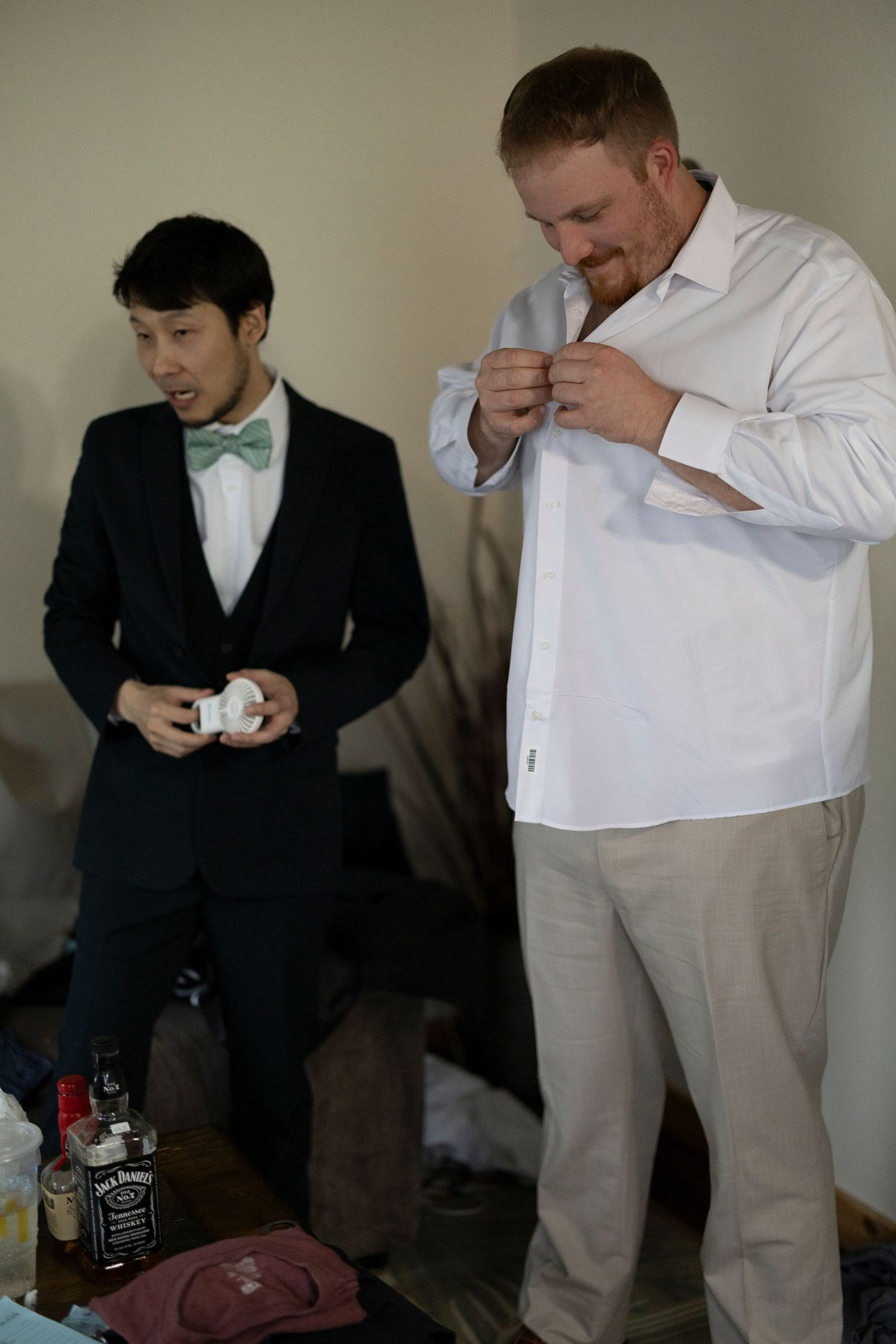 A sequence of photos showing two men getting ready, with one in a dark suit and another in light colored pants.