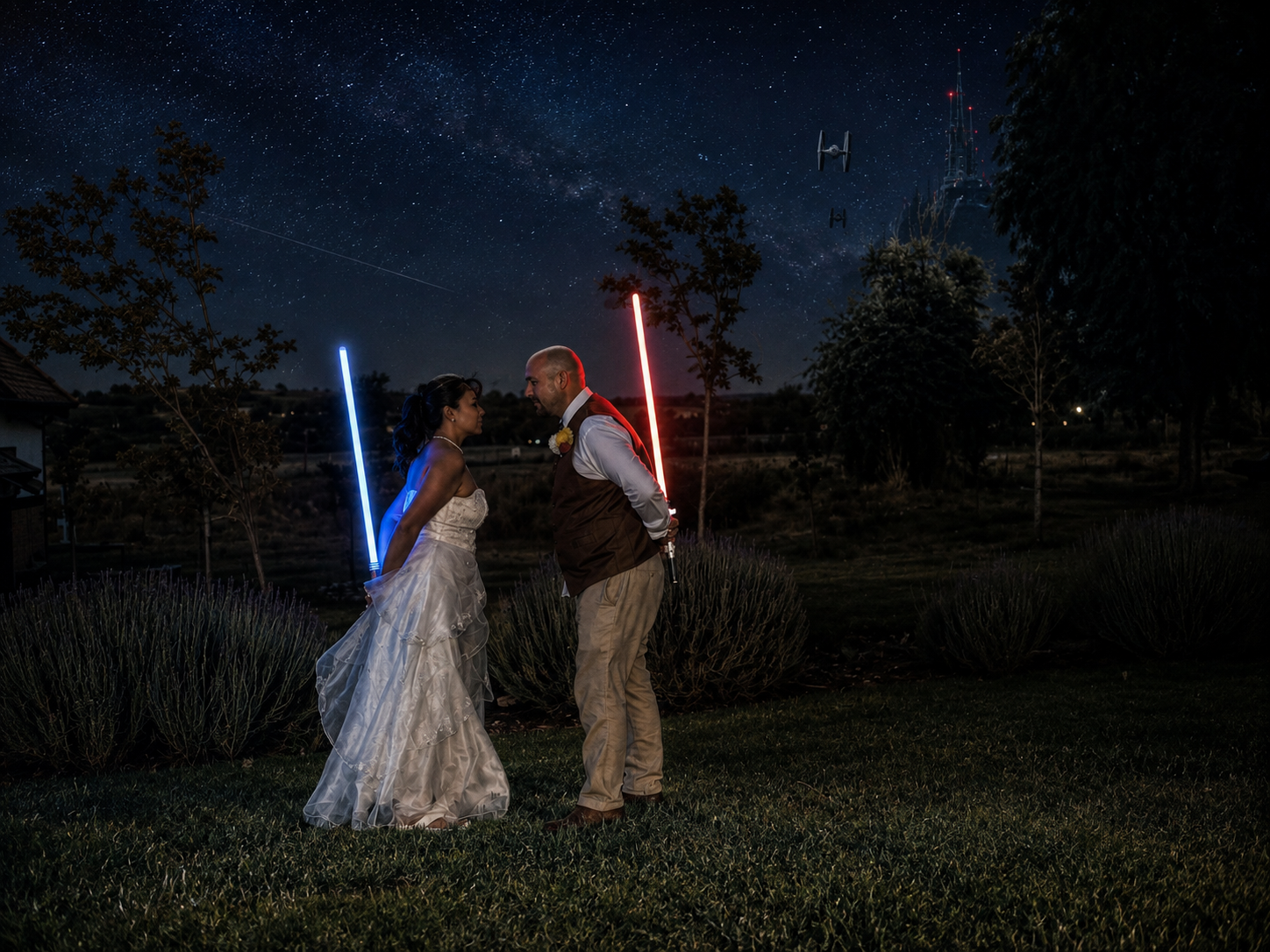 Bride and groom hold lightsabers under a starry night sky at their Star Wars themed wedding outdoor ceremony.
