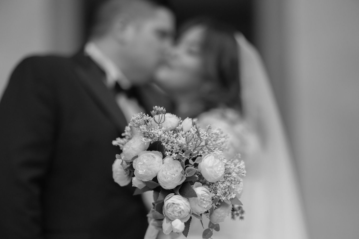 A black and white collage of wedding photos showing floral arrangements, bouquets, and romantic moments.