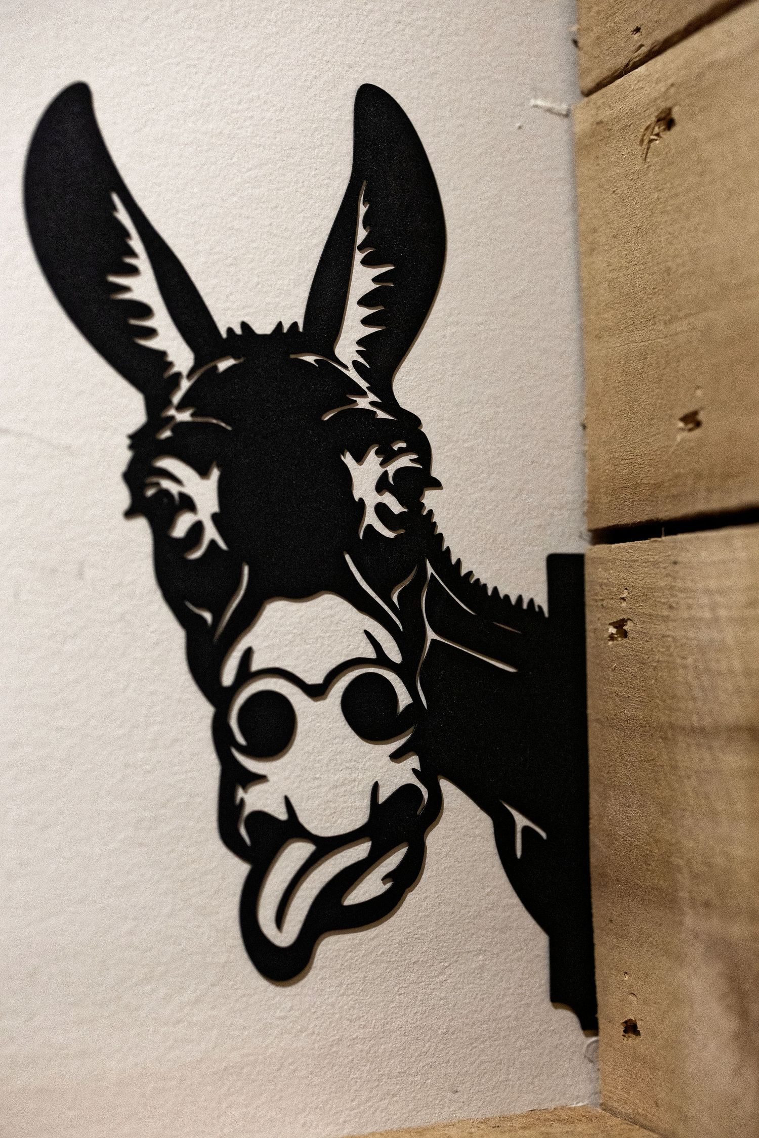 Four black silhouette art pieces show close-up portraits of a donkey's face with expressive features on a light background.