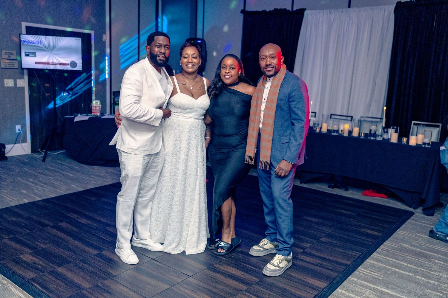 People in casual attire posing together at what appears to be a social gathering or party.
