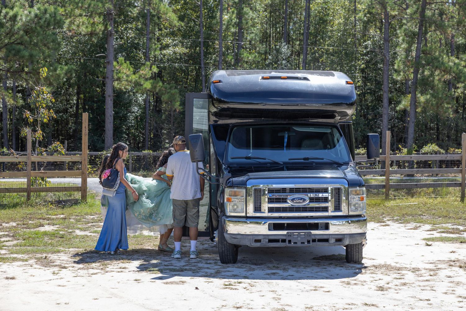 RV campers enjoying a sunny day at a forested campground with their Ford E-Series motorhome.