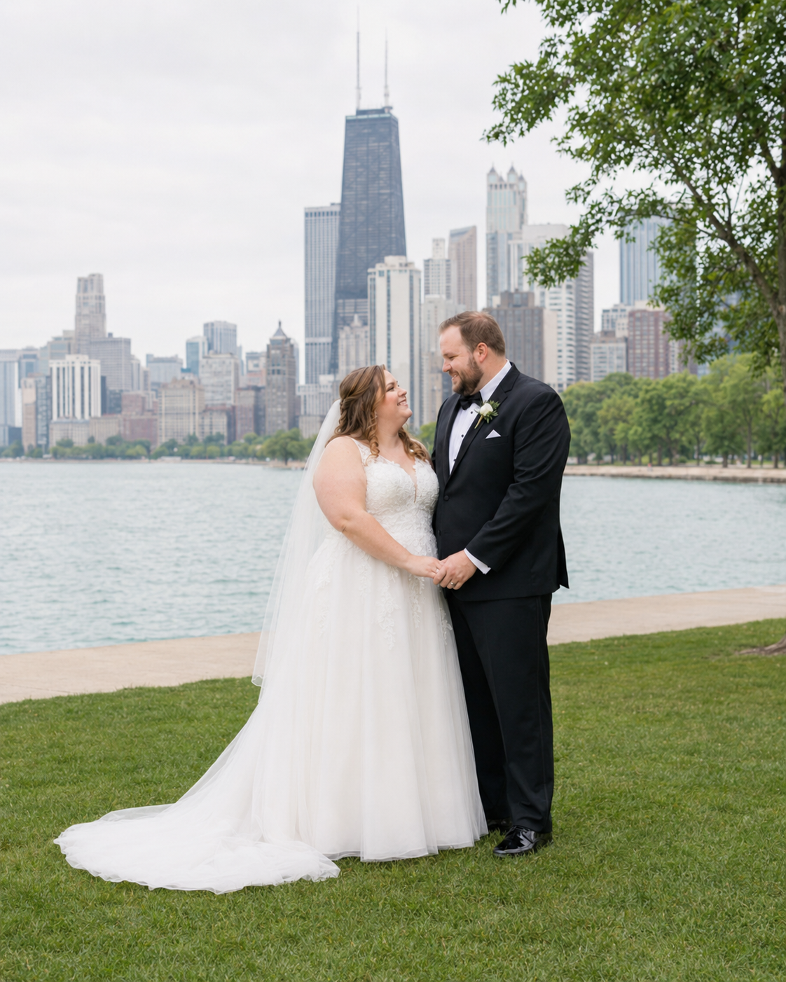 A bride and groom share a romantic moment by Lake Michigan with the Chicago skyline backdrop on their wedding day.
