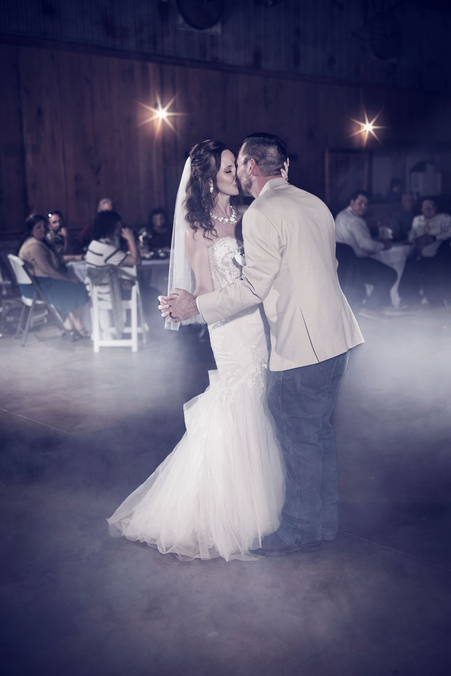 A romantic first dance at a wedding reception with fog effects creating a dreamy atmosphere on the dance floor.