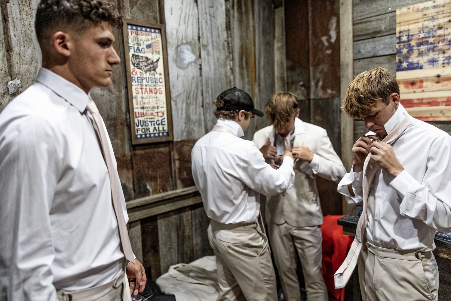 A group of people in white coats gather in a narrow alley for what appears to be a cigarette break.