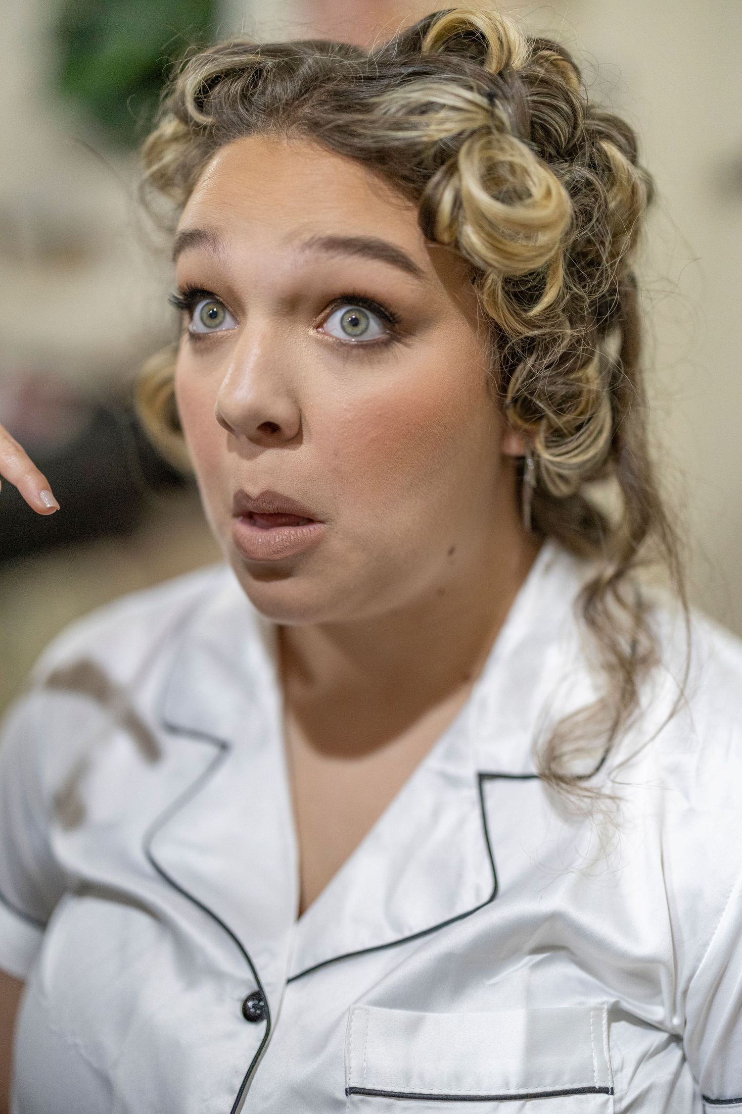 Close-up portrait series showing curled blonde hair and white shirt with dark trim in different angles.