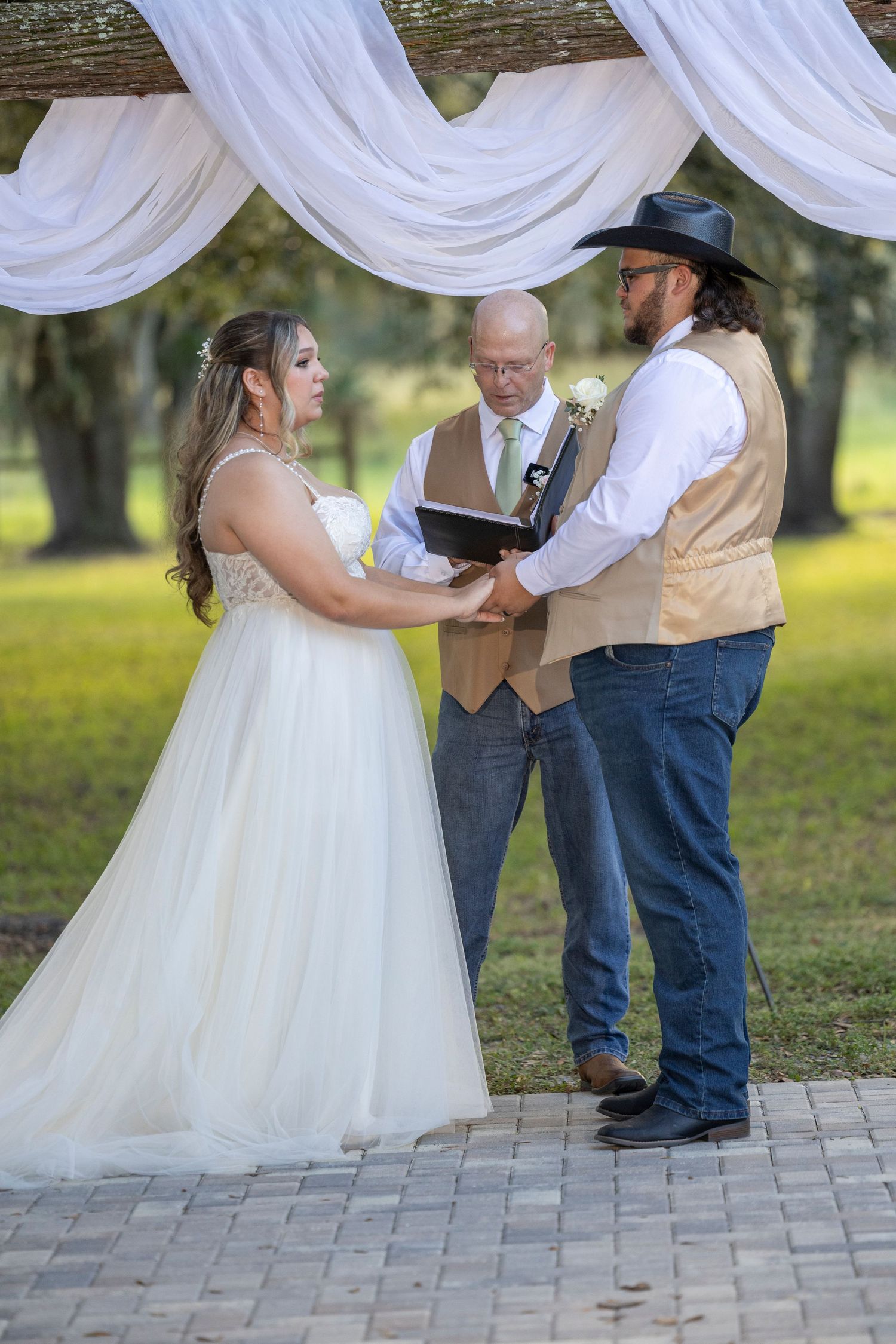 A couple shares a romantic dance moment on a stone patio during their rustic outdoor wedding celebration.