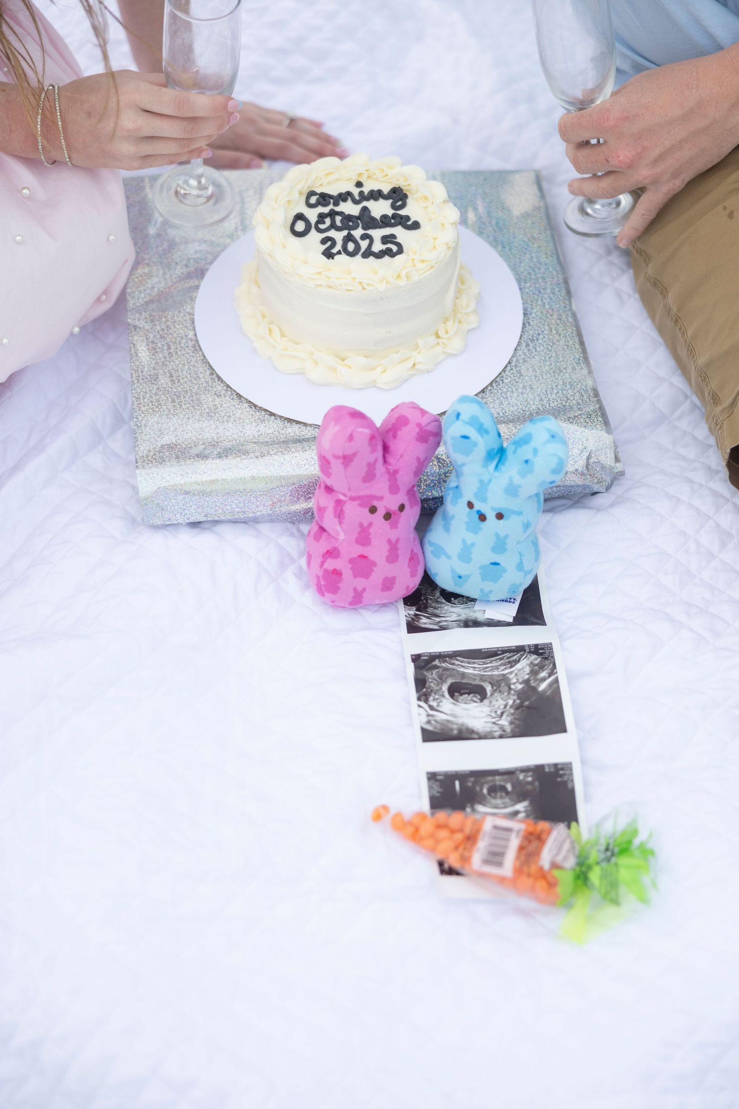 Baby announcement cake reading Coming October 2025 with pink and blue bunny Peeps and ultrasound photos.
