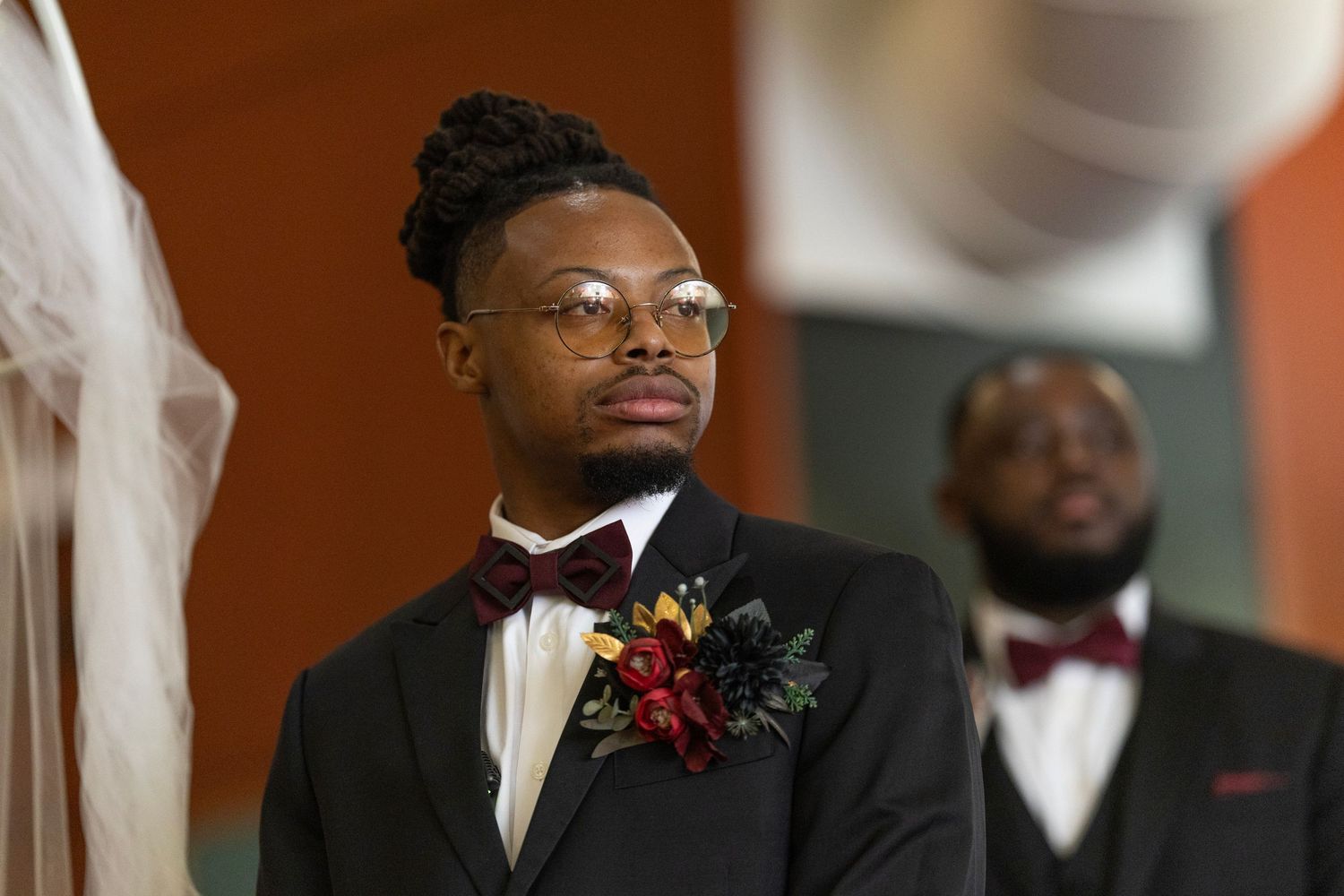 A group of groomsmen in black tuxedos and bow ties pose together at a formal wedding event.