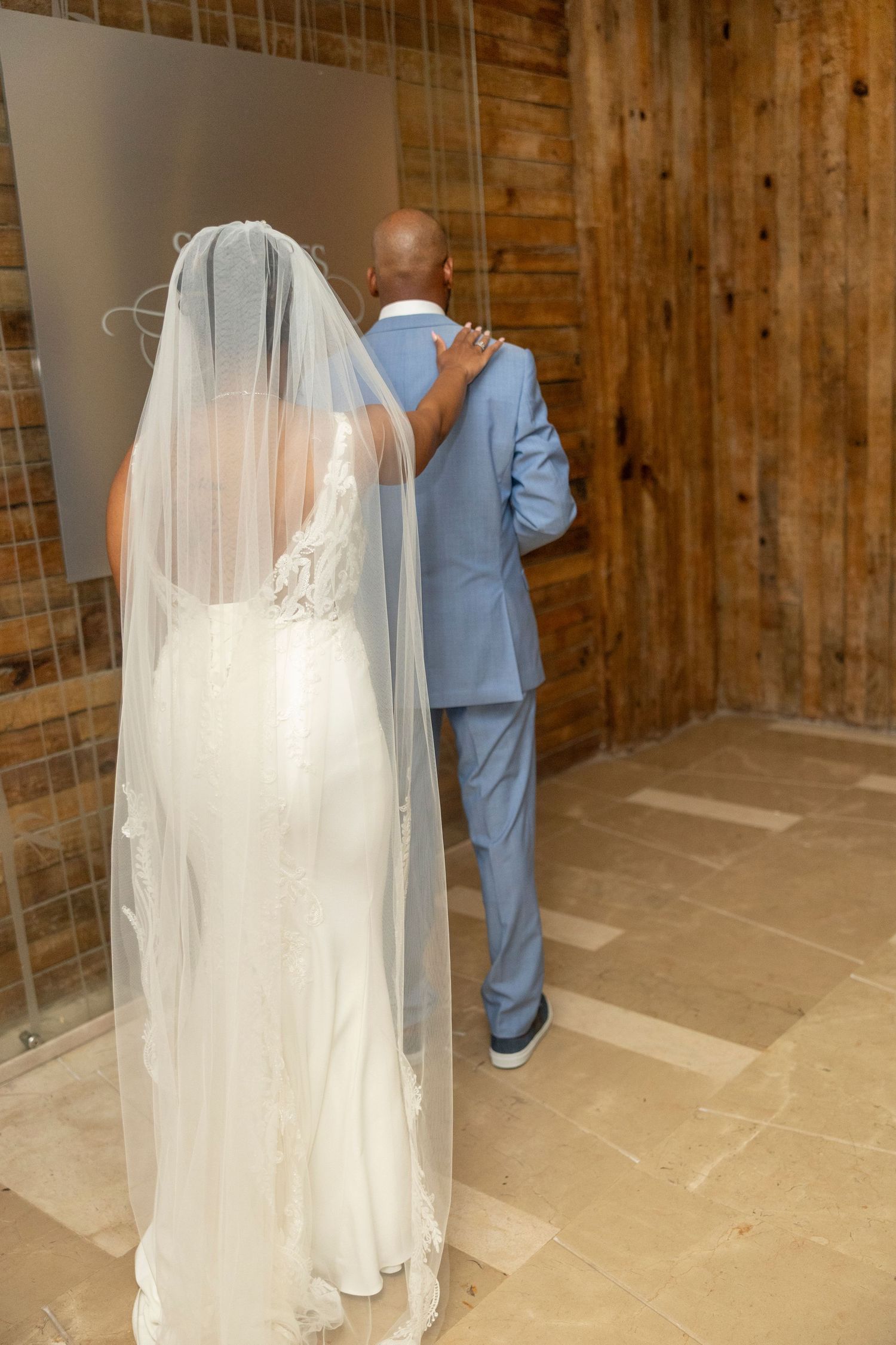 A sequence of first look photos showing a bride in a white wedding dress and veil approaching someone in a blue suit.