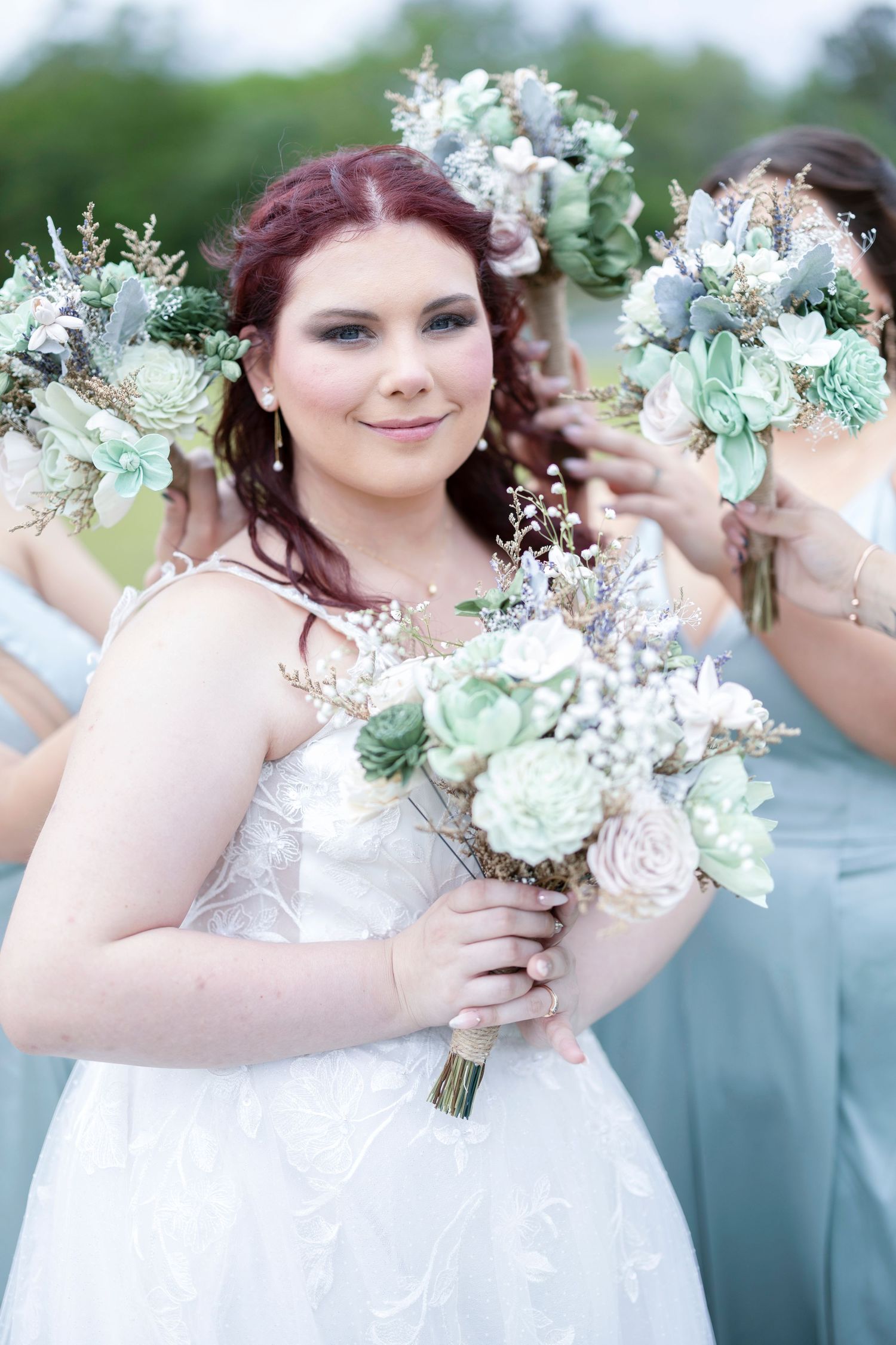 A wedding bouquet featuring soft mint green and white flowers with delicate foliage creates an elegant bridal arrangement.