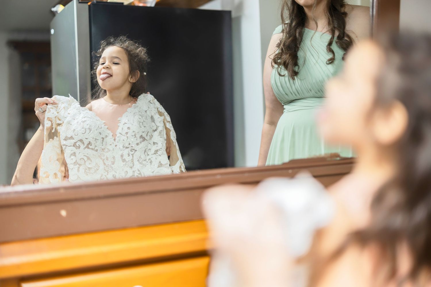 A group of bridesmaids in mint green dresses laugh and smile together during a wedding celebration.