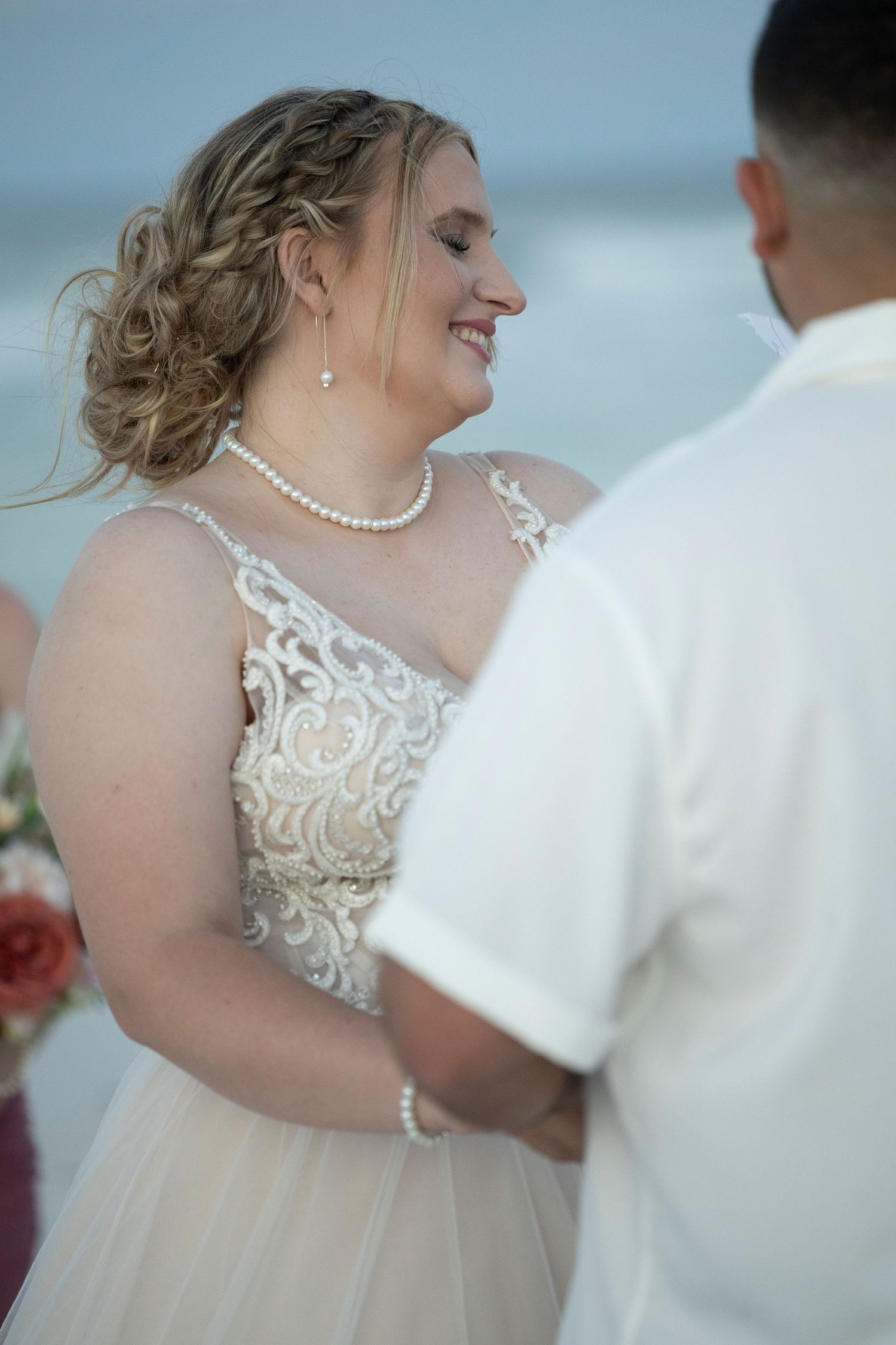 A couple shares a romantic dance moment at their wedding, with the bride wearing an elegant lace and tulle gown.
