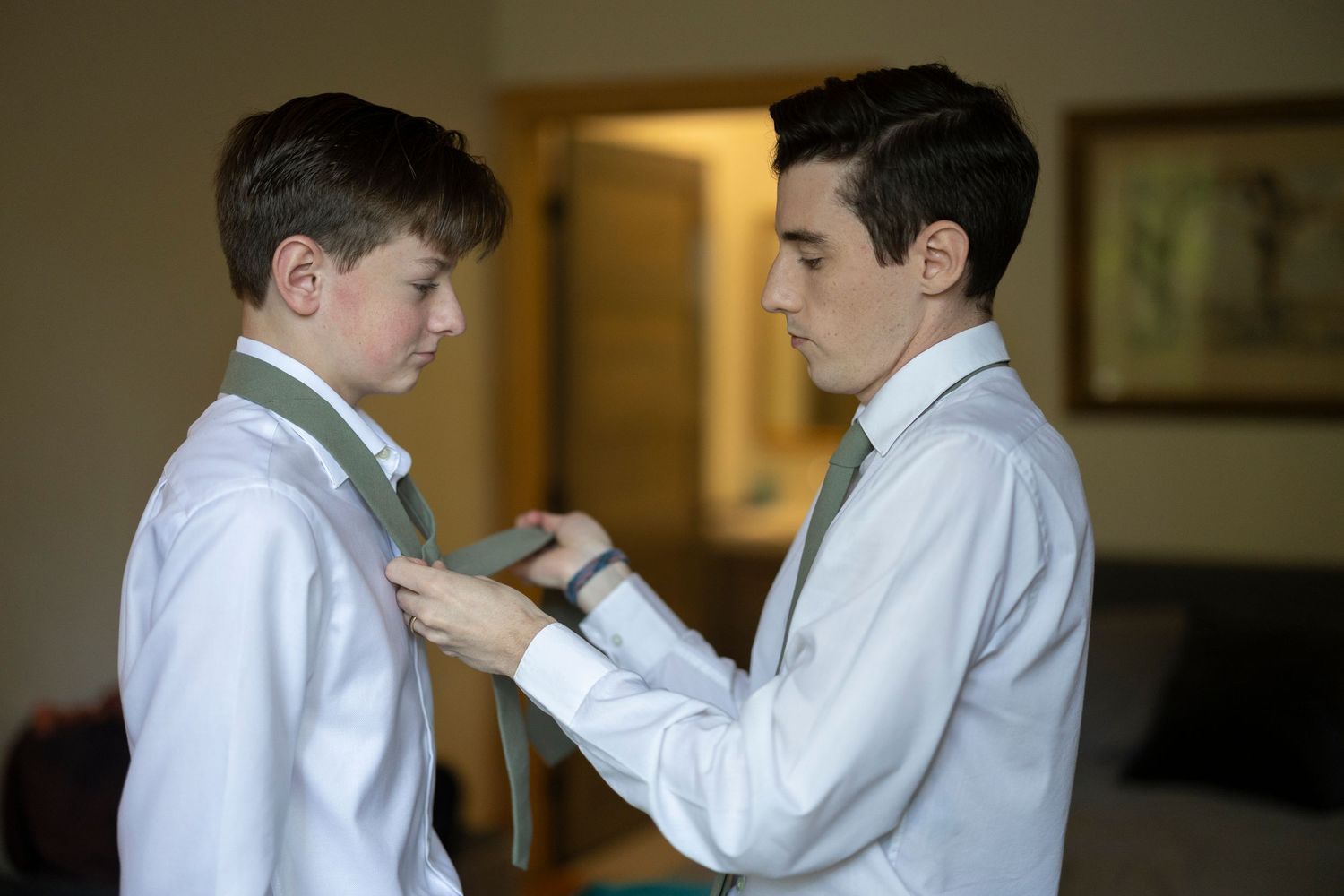 Two students in white uniforms practice martial arts techniques together in a training studio.