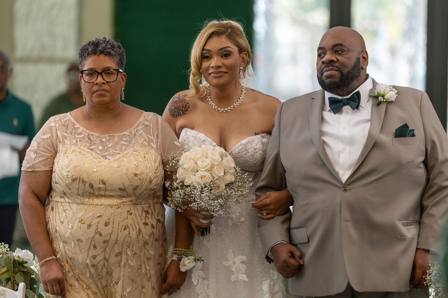 Wedding party members wearing champagne and gray formal attire pose together during elegant celebration.