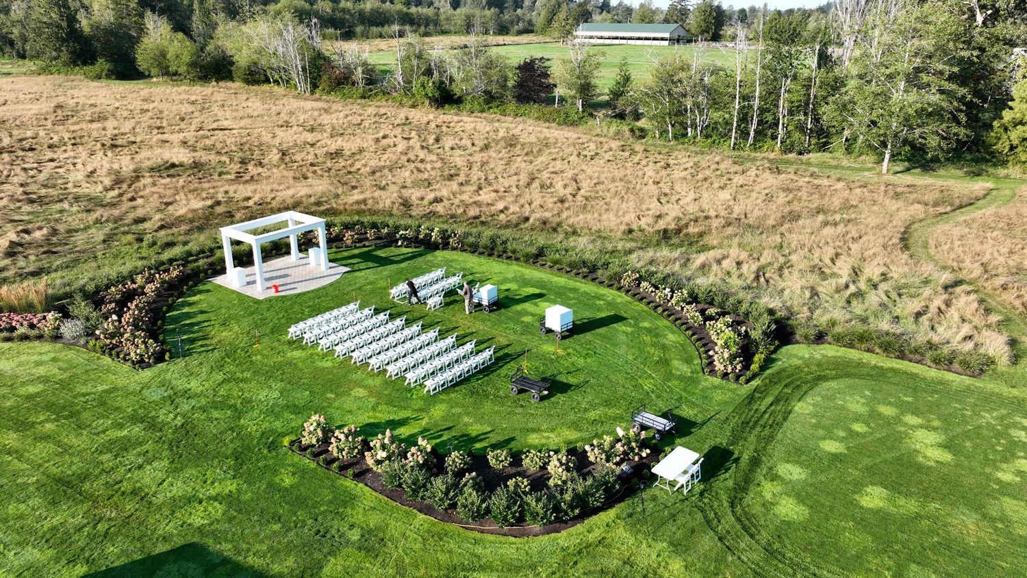Panoramic aerial view of a lush green golf course with rolling hills, trees, and manicured fairways.